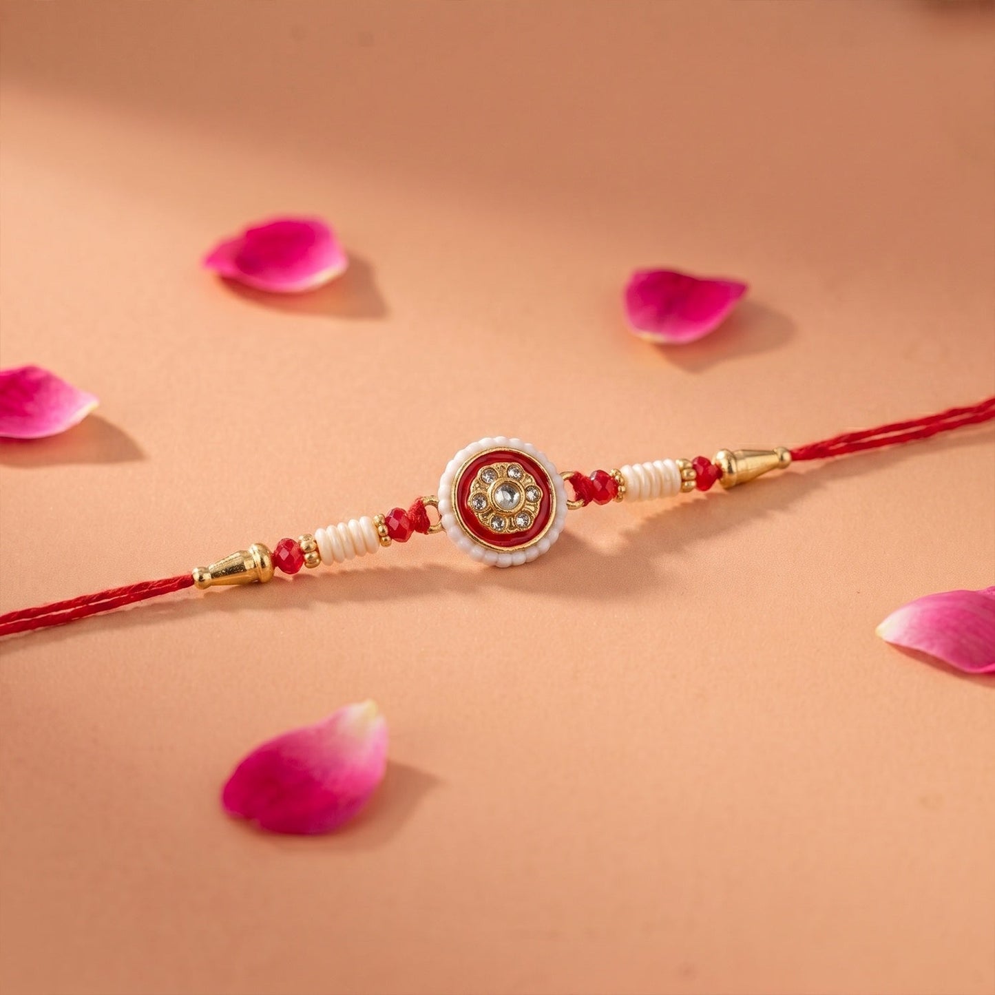 Designer red Rakhi with pearl and bead accents, ideal for Raksha Bandhan