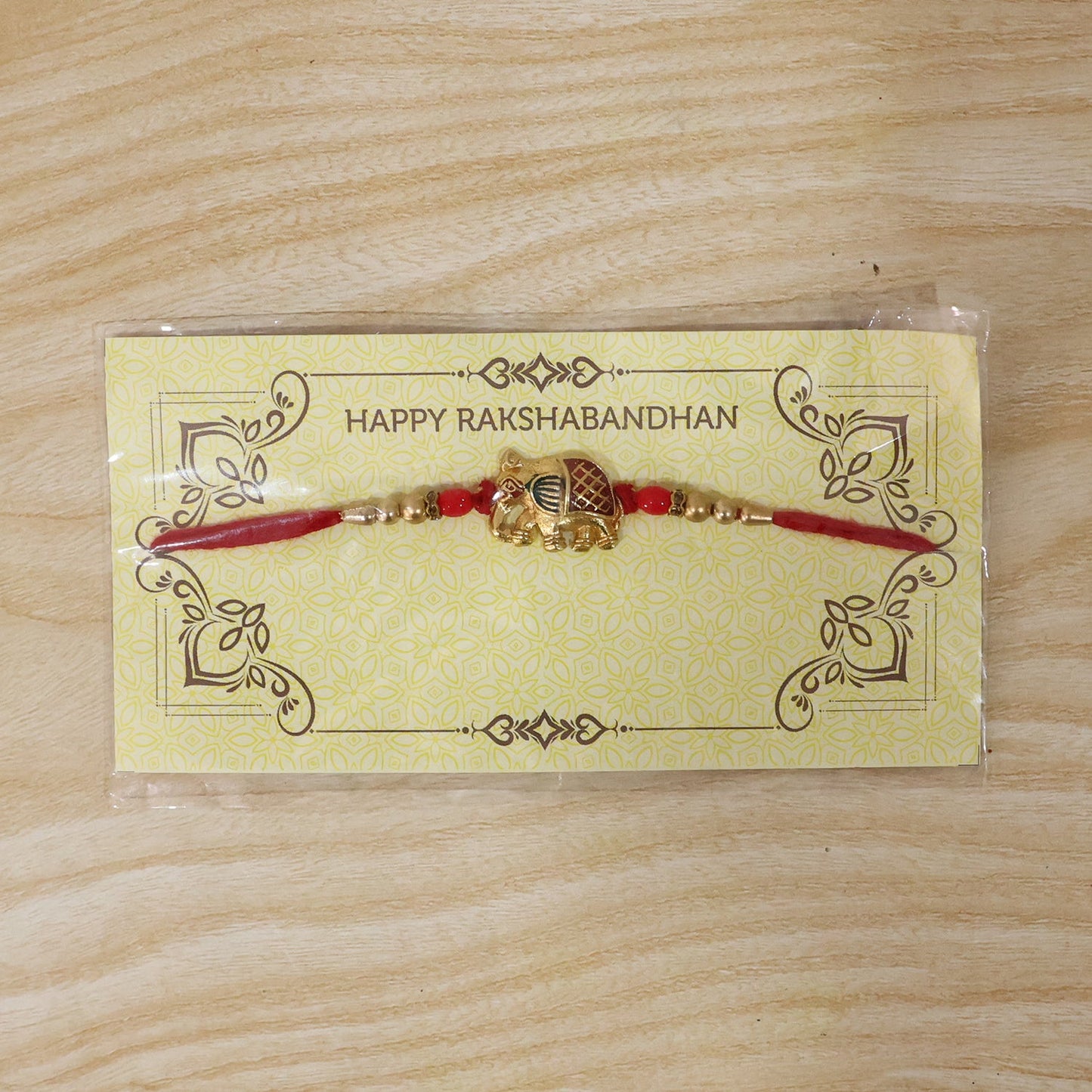 Detailed view of decorative elements on gold elephant rakhi