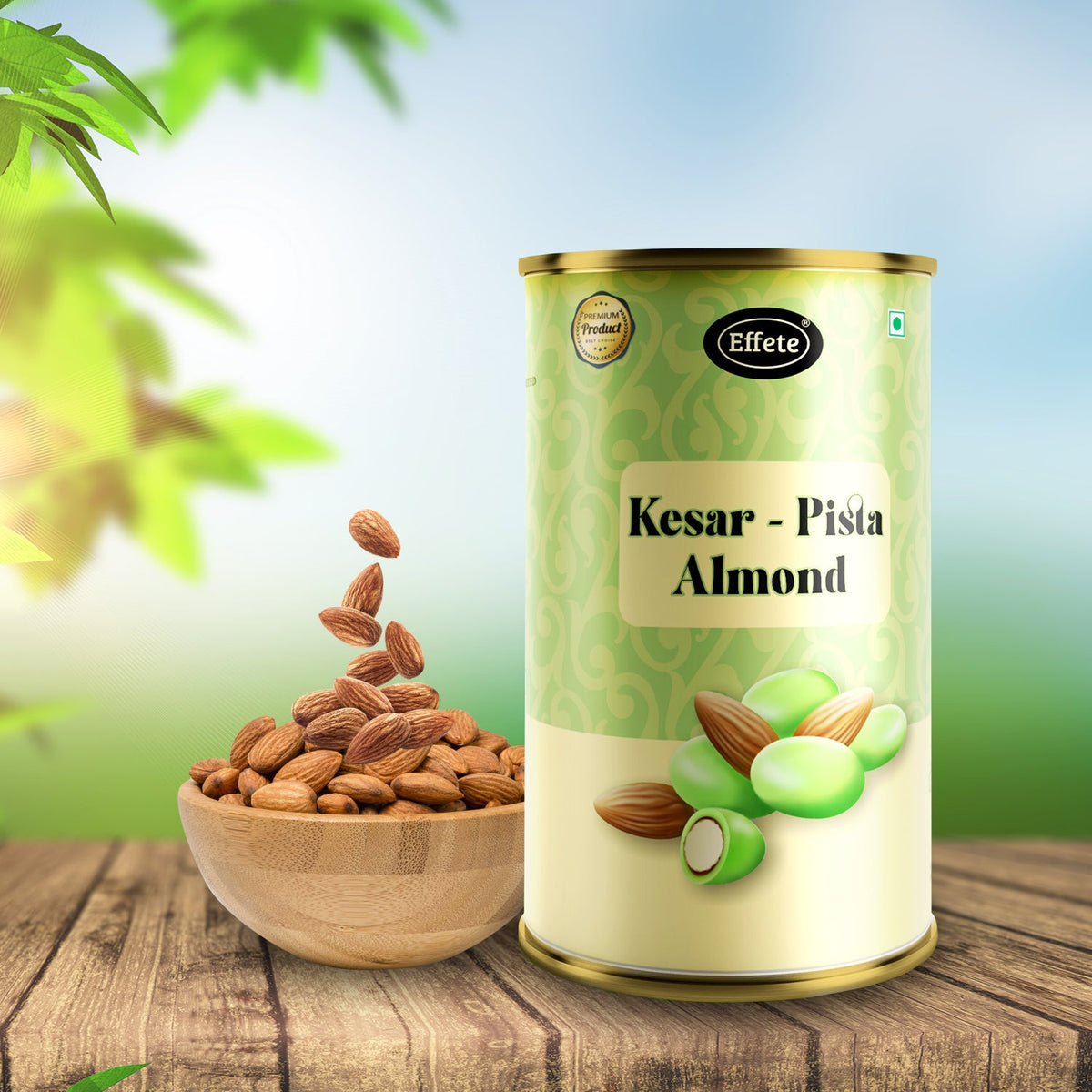 A tall tin of Kesar Pista Almonds sits on a wooden table next to a bowl of falling almonds.