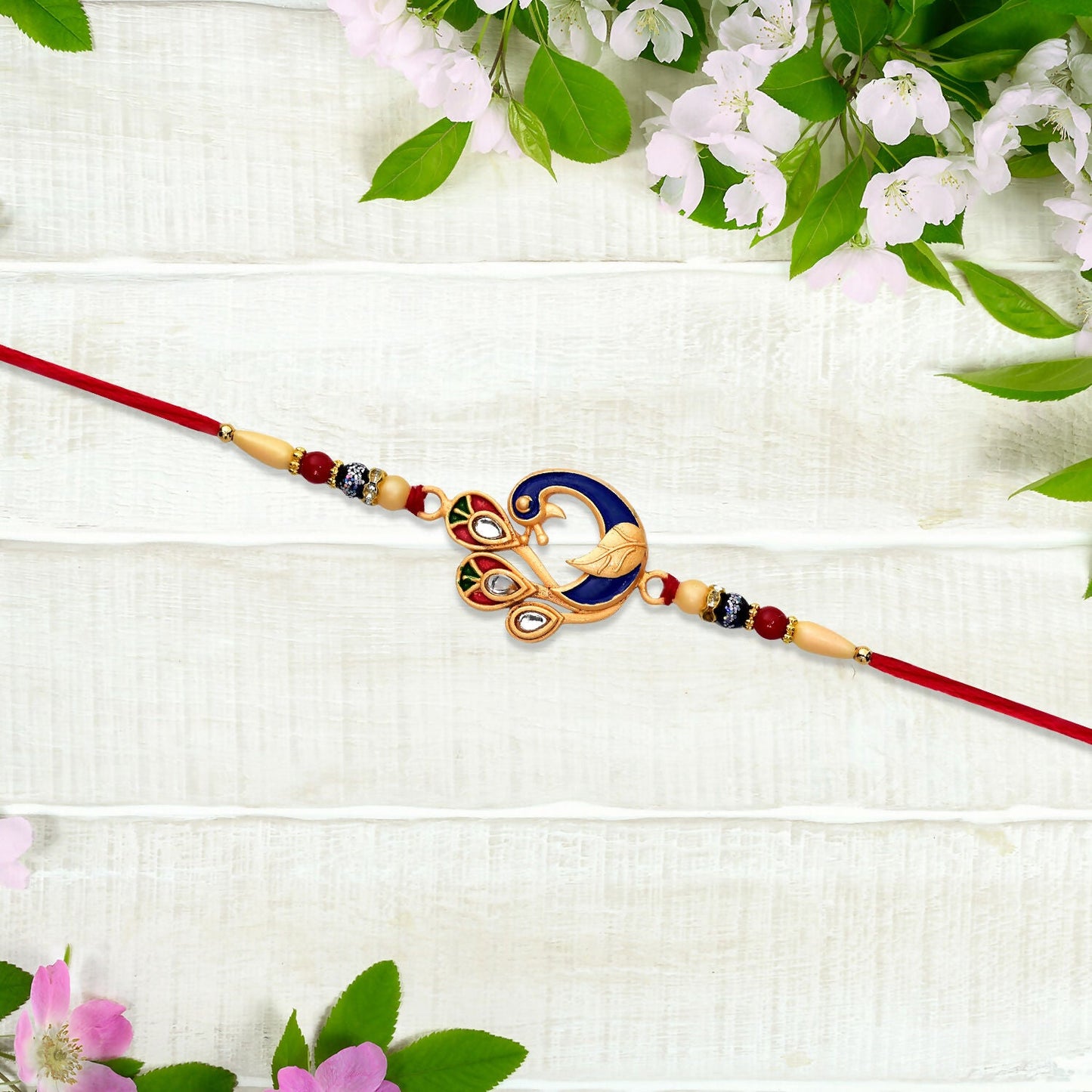 Detailed traditional Meenakari work on a vibrant Rakhi thread for brother.