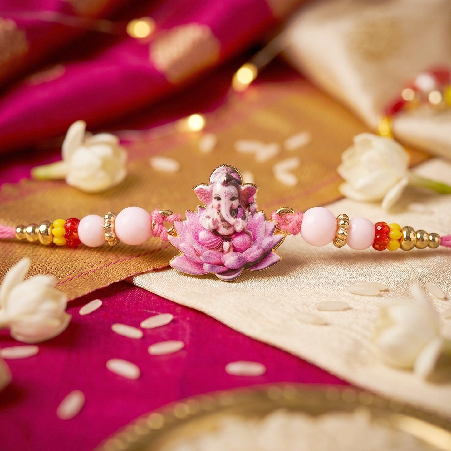 Side view of Lord Ganesha pink lotus Rakhi showing thread detail