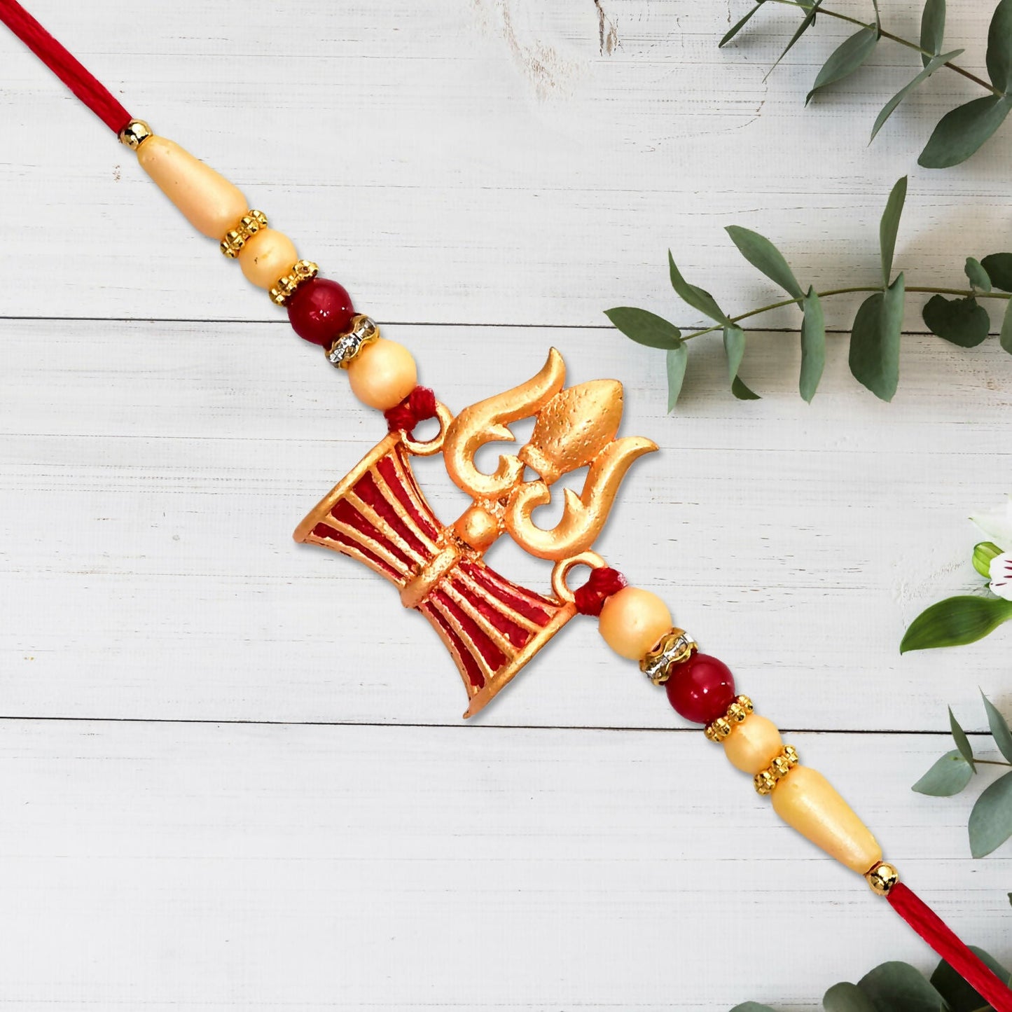 Designer Shiva Trishul Rakhi displayed on white background showcasing its spiritual design.