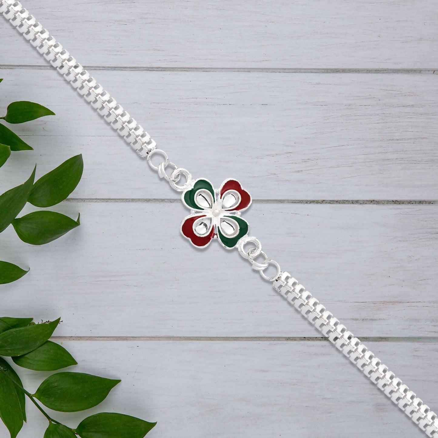 Close view of floral Tricolor Enamel Rakhi with silver-tone metal chain.