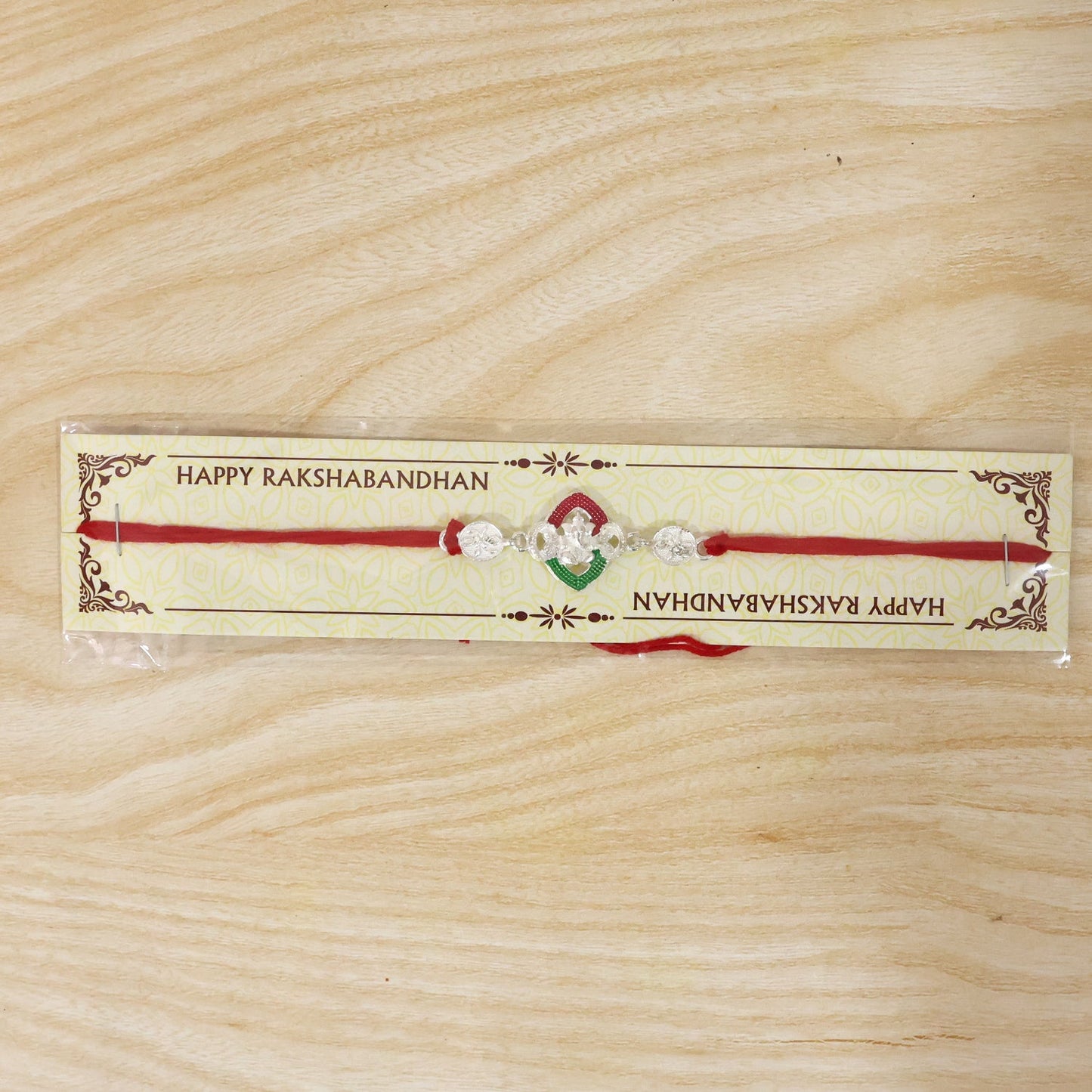 Silver Green Floral Rakhi presented on a decorative card