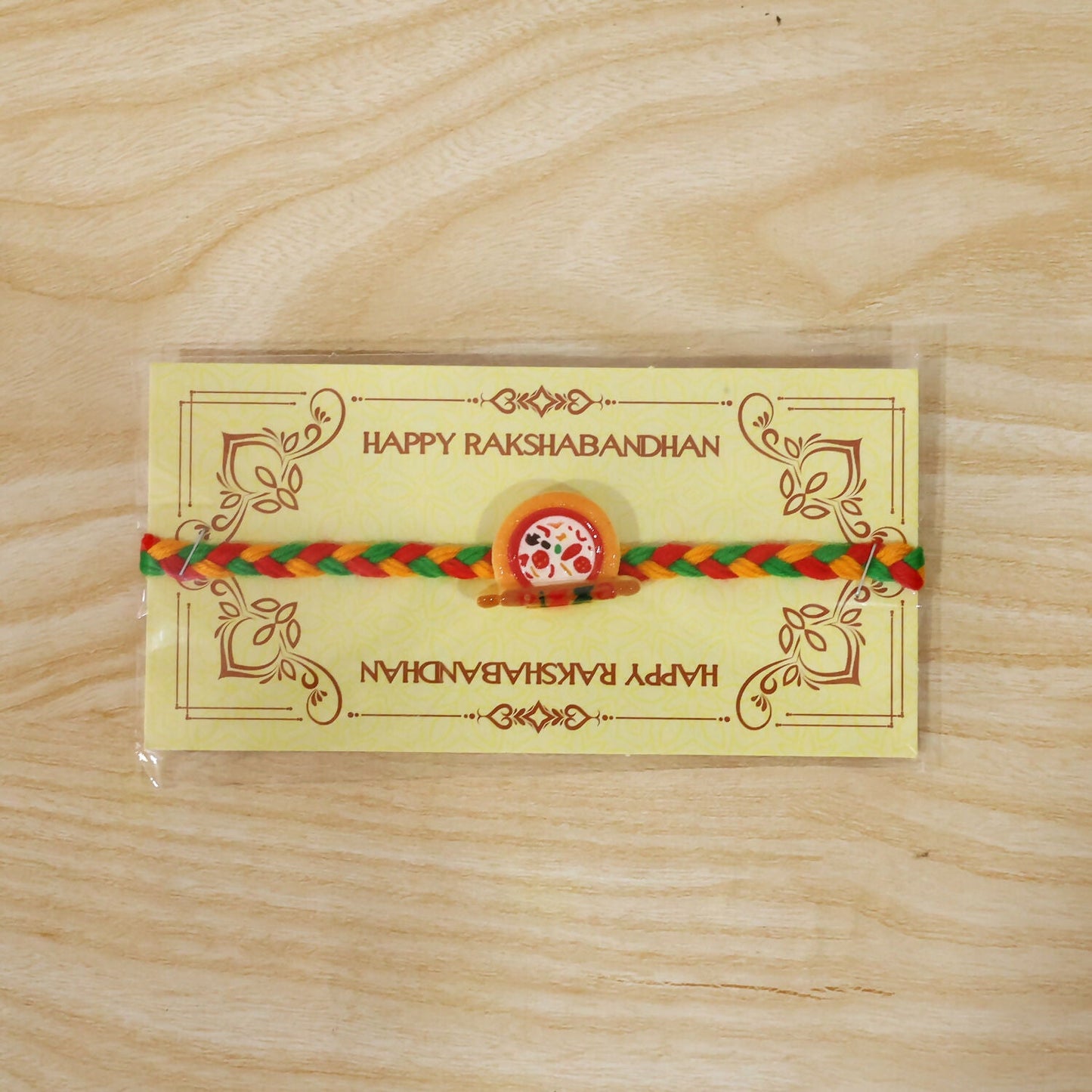Tied view of kids rakhi with pizza charm on wrist