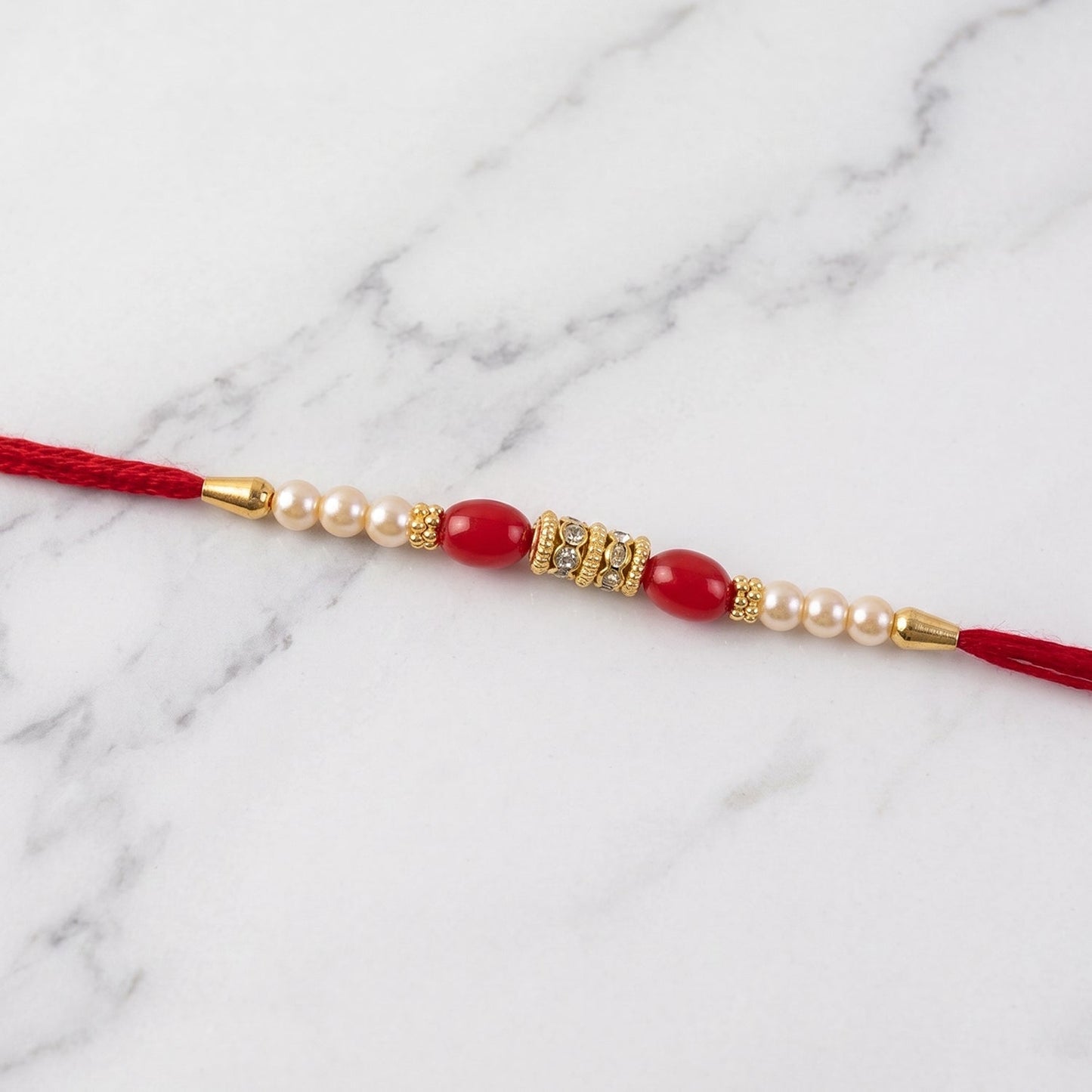 Festive Rakhi design featuring pearl, moti, and gold accents