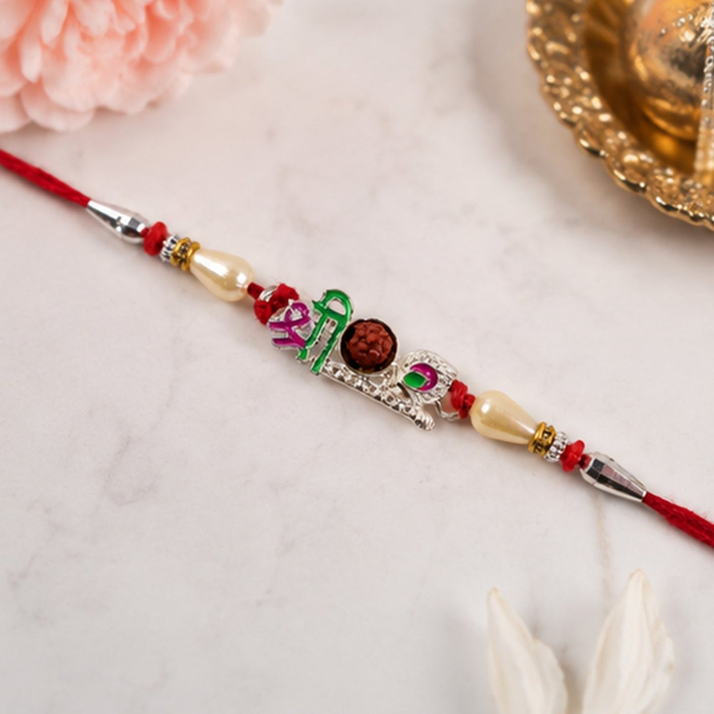Close-up of Rudraksha center and pearl beads on festive rakhi