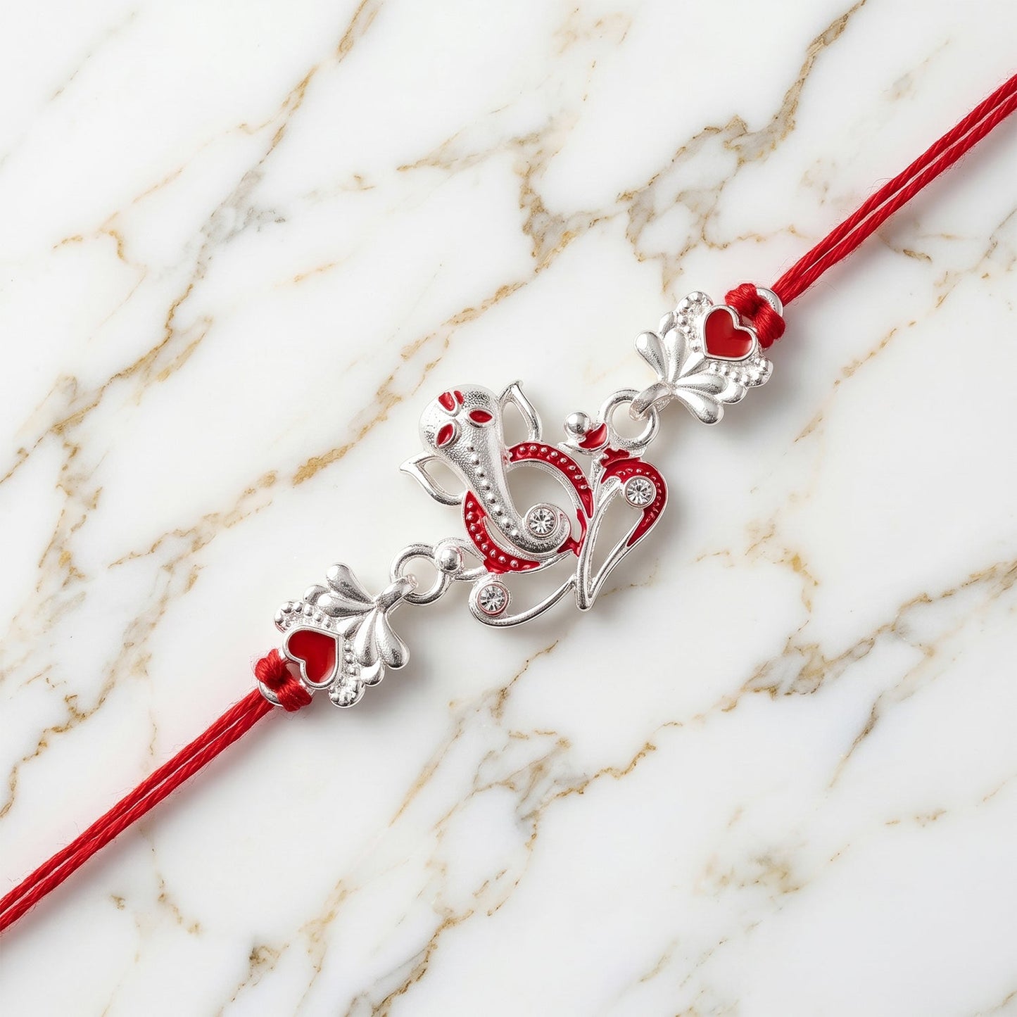 Silver Ganesha rakhi in elegant packaging, ready for gifting during Raksha Bandhan.