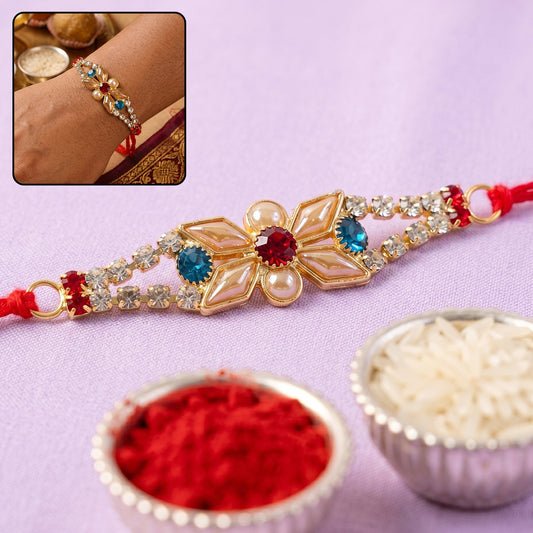 Close-up of pastel floral Kundan Rakhi with blue stone and pearl center