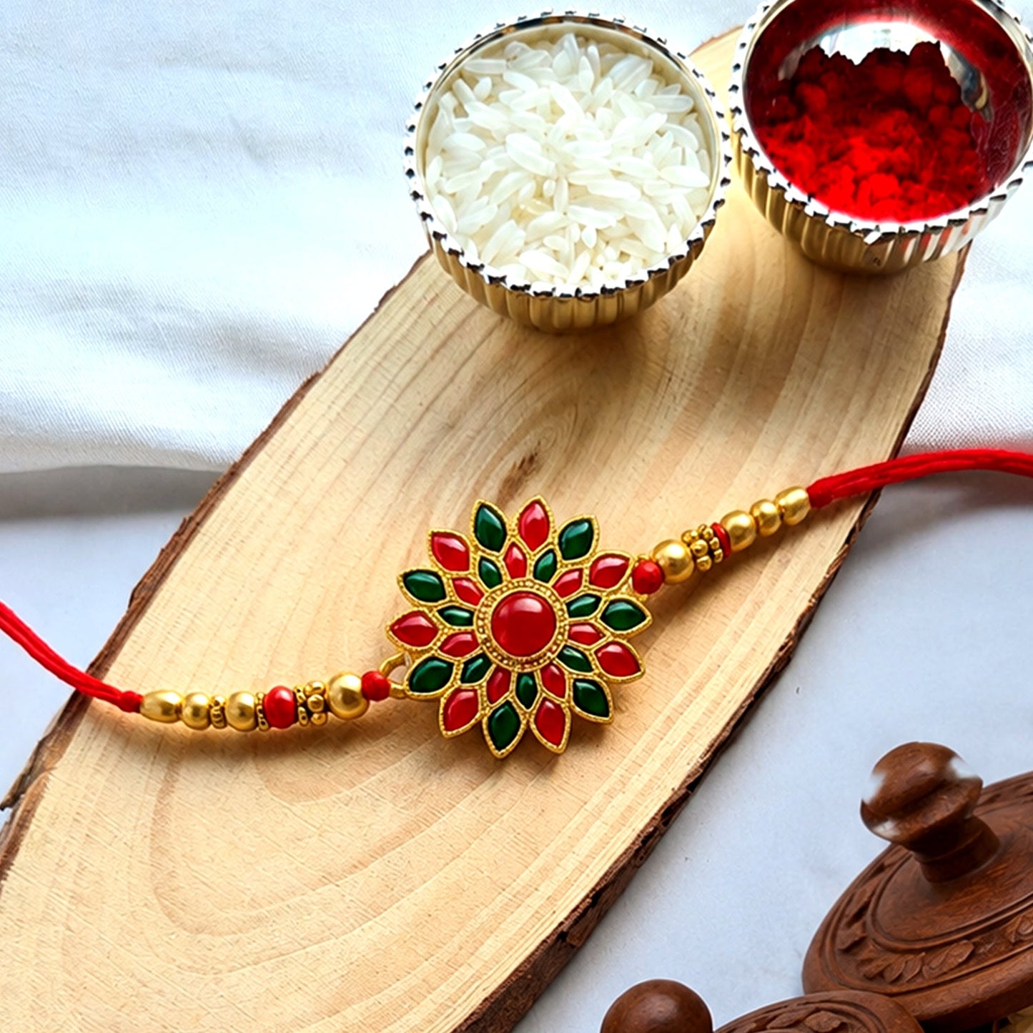 Red and green stone flower design Rakhi on white background