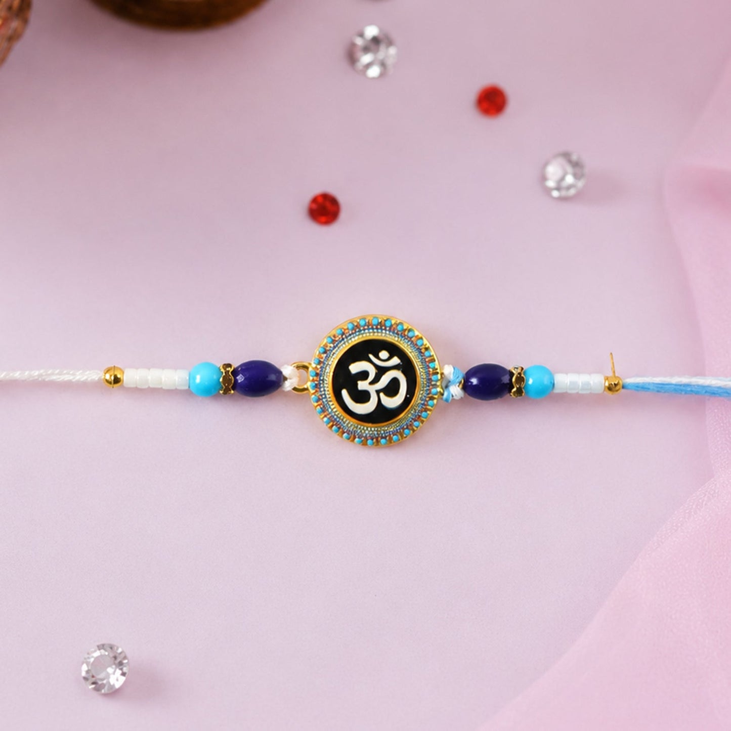 Close-up of Om Designer Rakhi with blue beads and elegant design