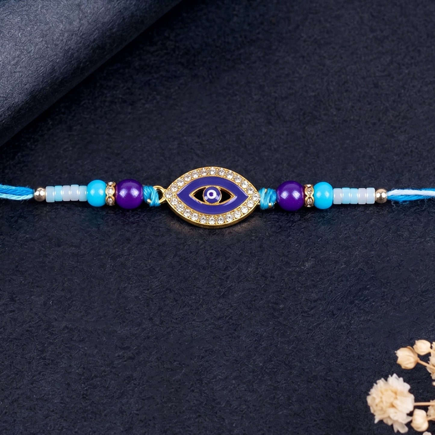 Vibrant blue evil eye bead Rakhi with traditional design