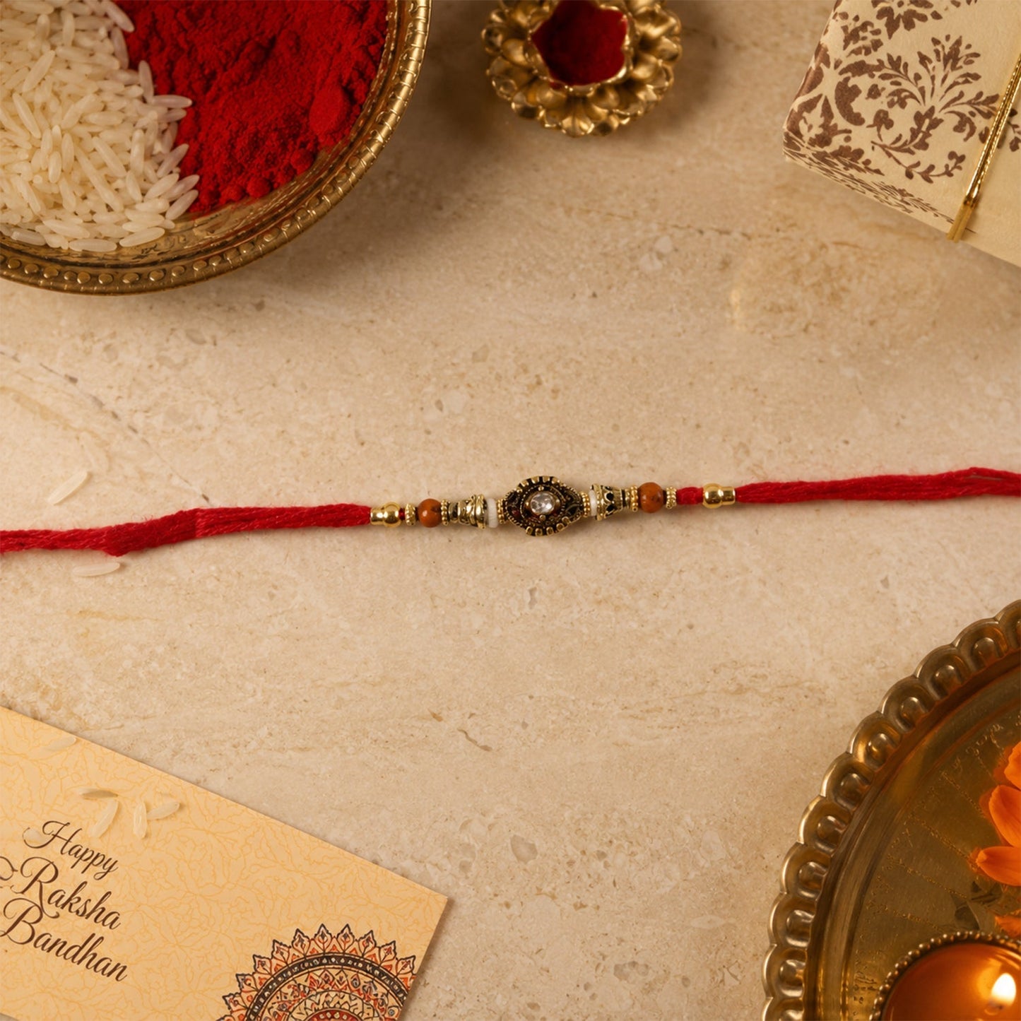 Hand holding Antique stone Bhabhi Rakhi with pearl beads
