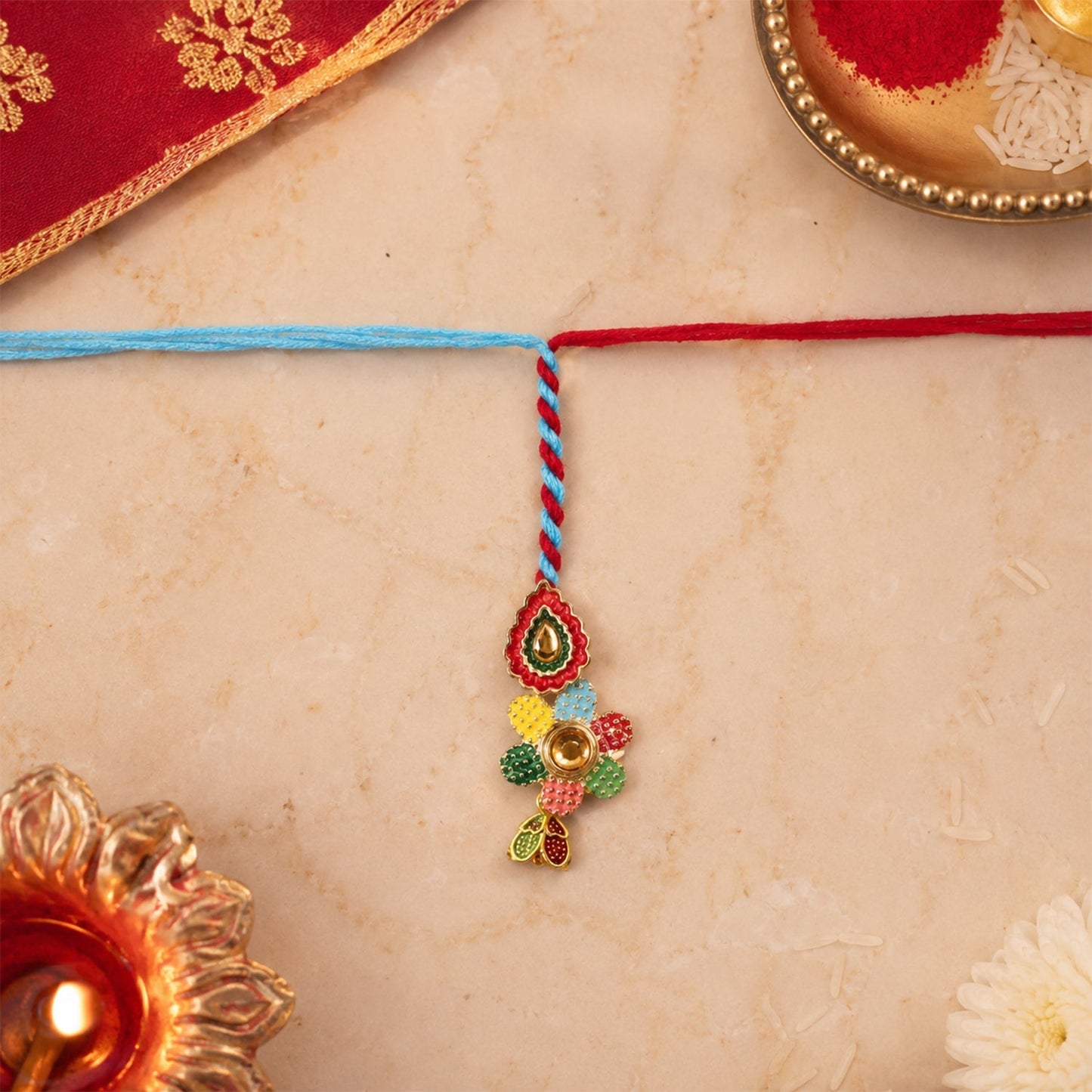 Close-up of traditional meenakari Rakhi with blue thread craftsmanship