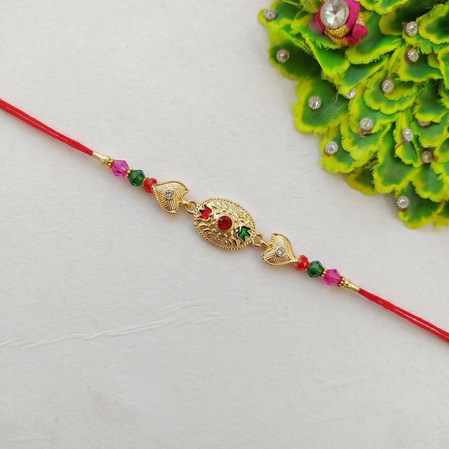 Golden oval Rakhi with colorful beads on soft thread