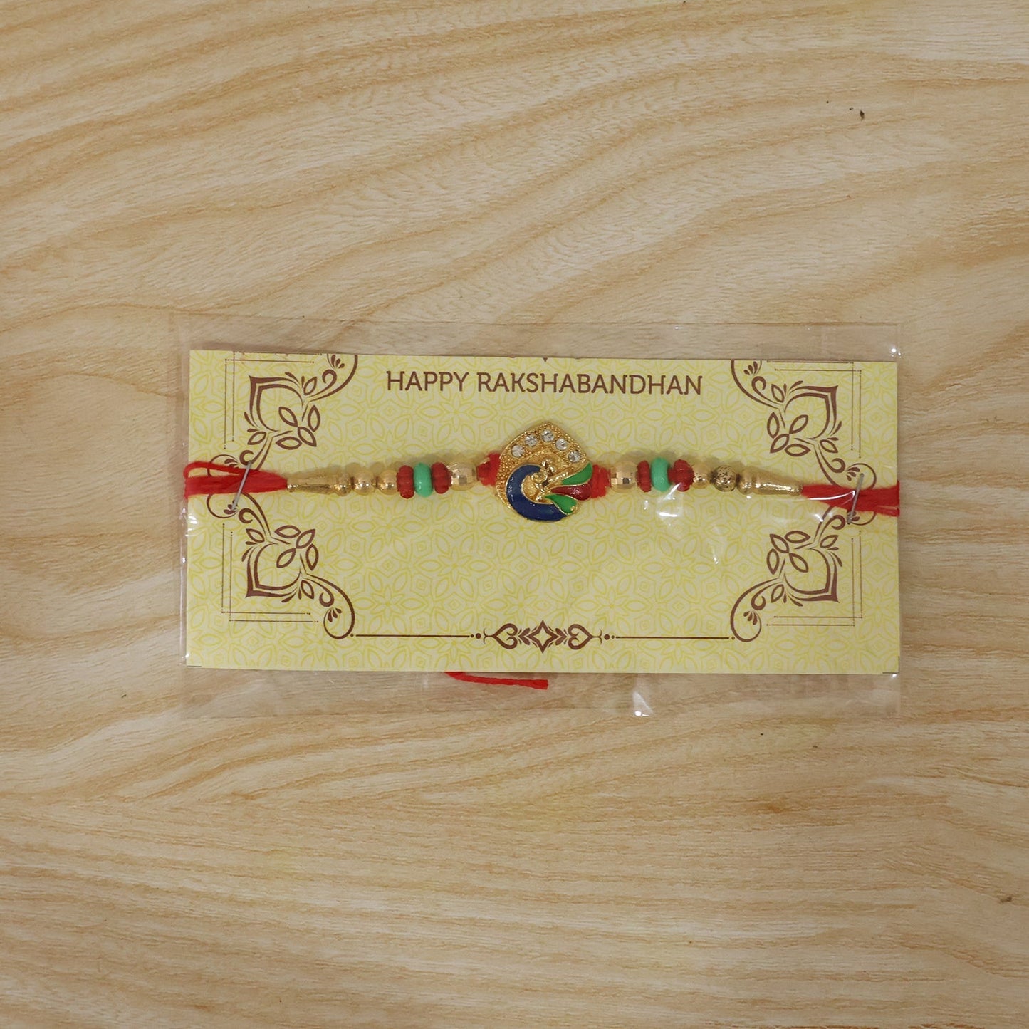 Full view of colorful peacock Rakhi laid flat, detailed design