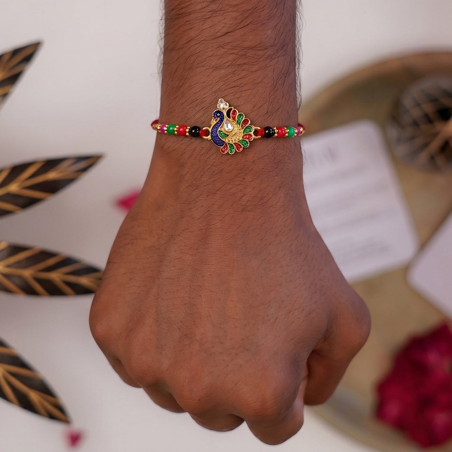 Close-up of peacock motif and multicolor beads on Rakhi
