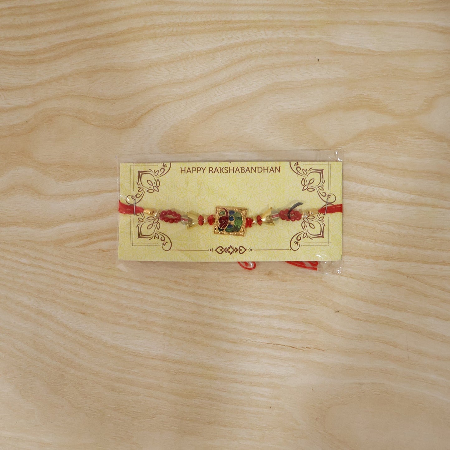 Traditional Rakhi with red beads laid on surface