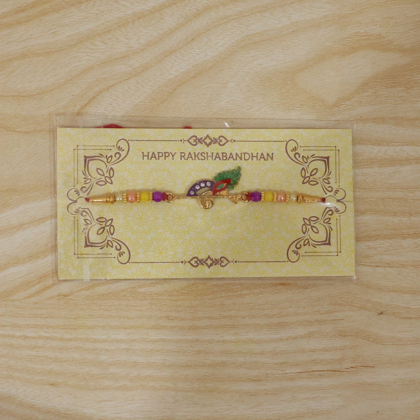 Peacock Feather Flute Rakhi in packaging, ready for gifting