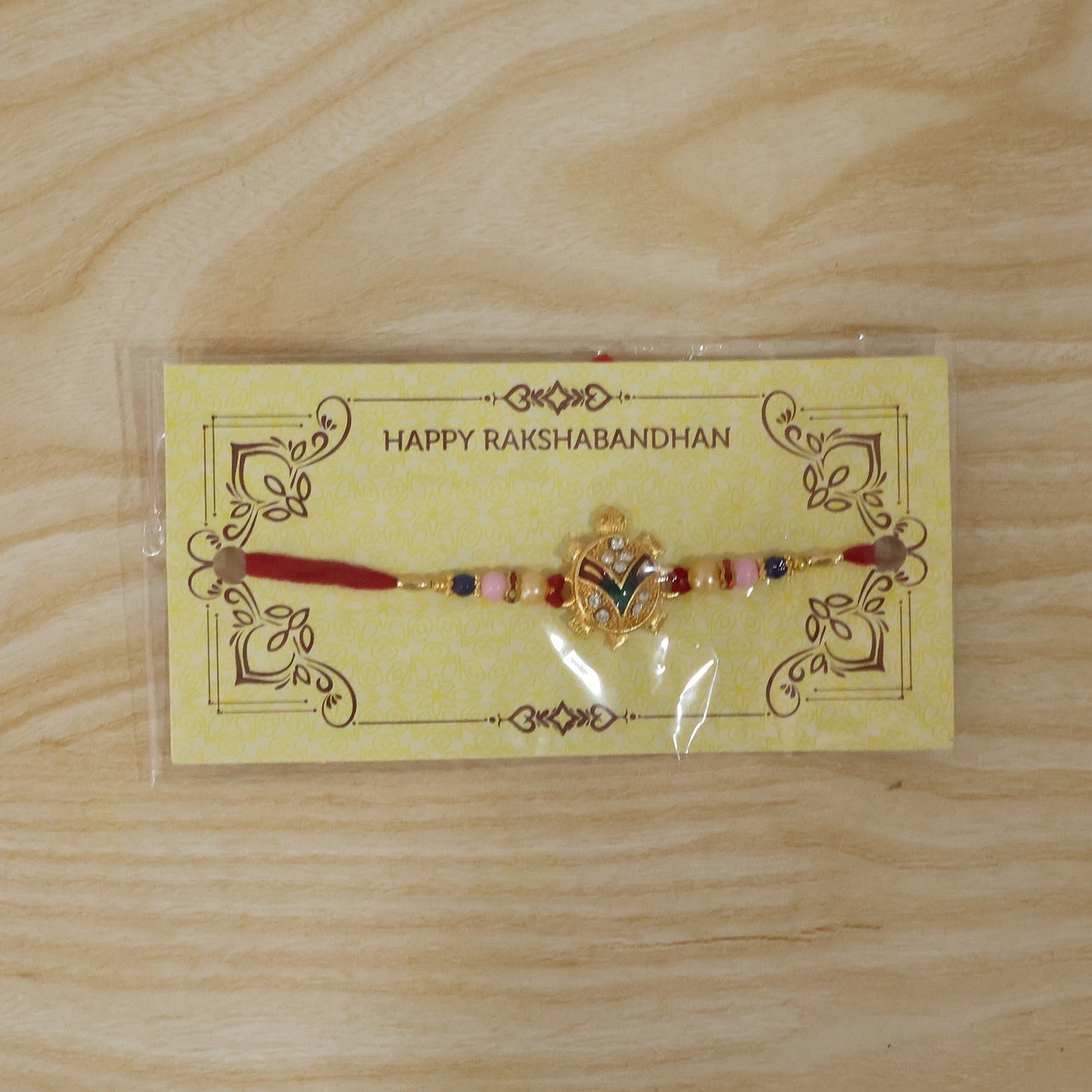 Festive golden turtle Rakhi featuring pearl beads on soft thread