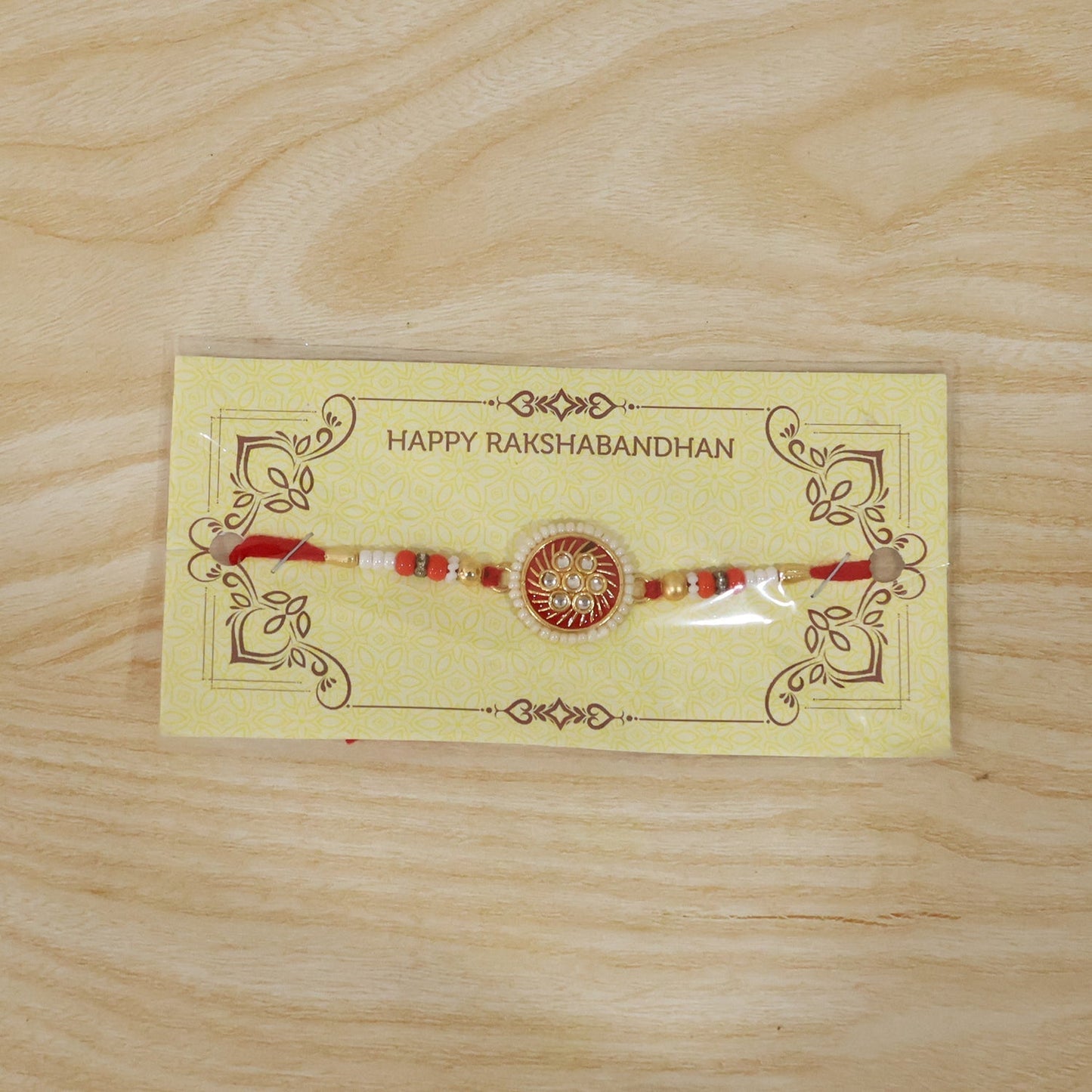 Festive Rakhi with golden floral centerpiece and bead embellishments