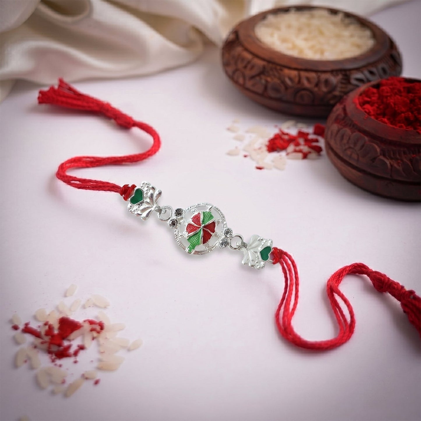 Side view of silver floral Rakhi with beads
