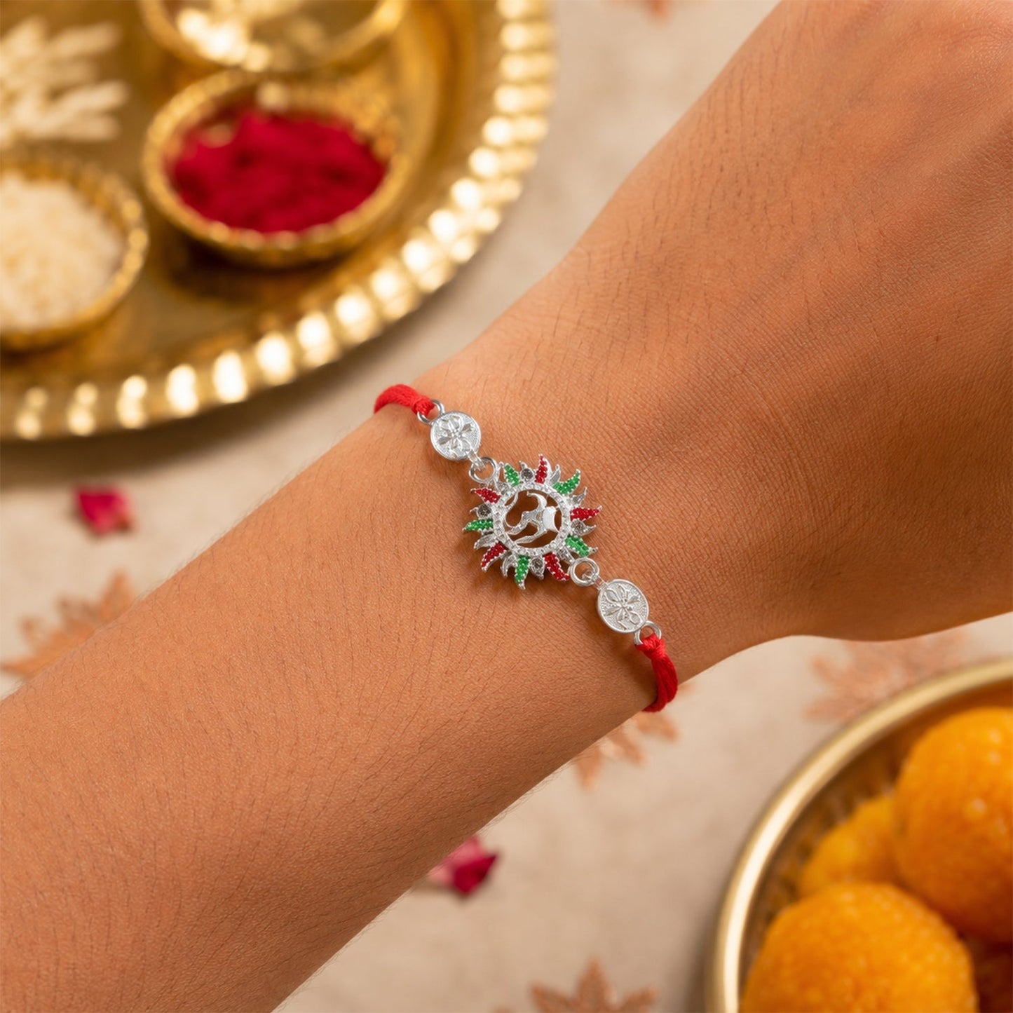 Close-up of Om design on red thread rakhi, traditional spiritual symbol