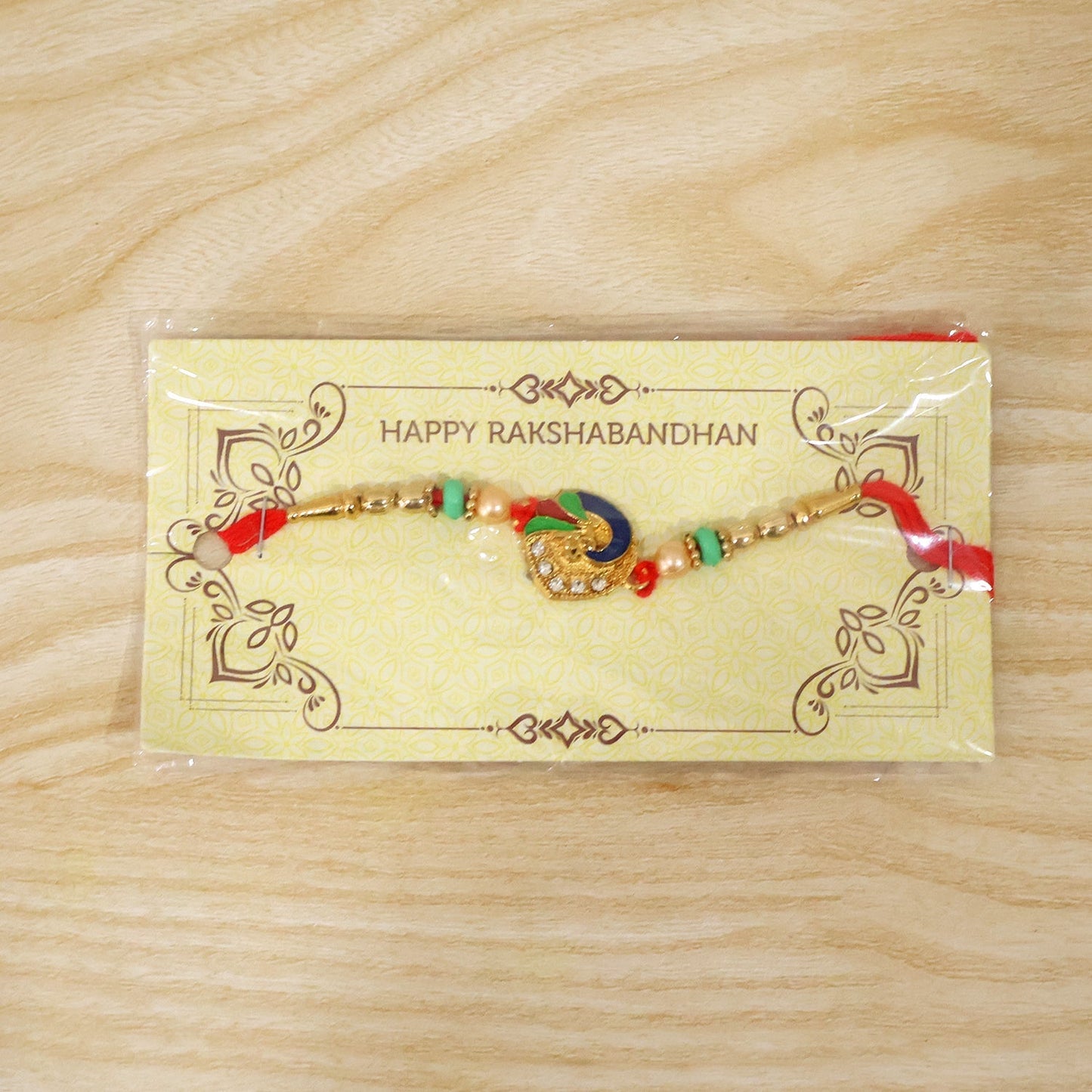 Peacock designer Rakhi with pearl beads and red thread