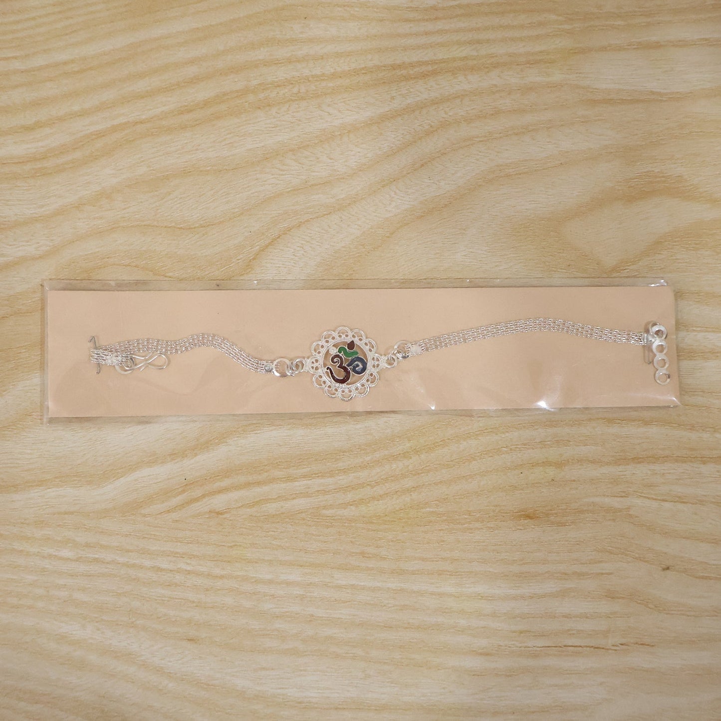 Eye-catching silver Om Rakhi with detailed design
