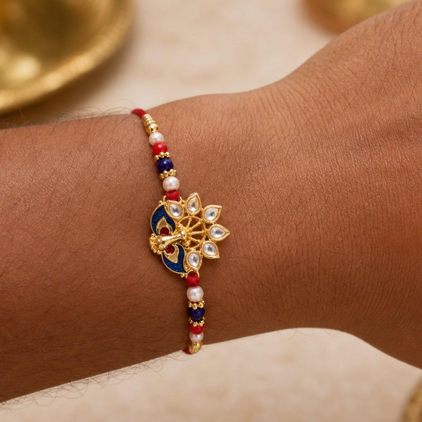 Top view of peacock rakhi showing pearl bead details and vibrant colors