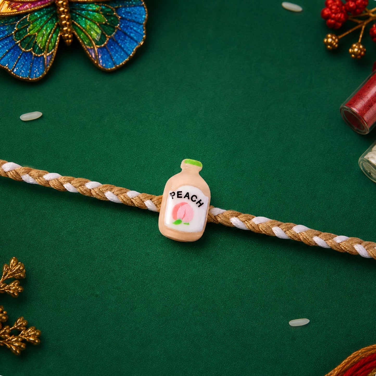 Close-up of peach bottle charm on the Rakhi for detailed look