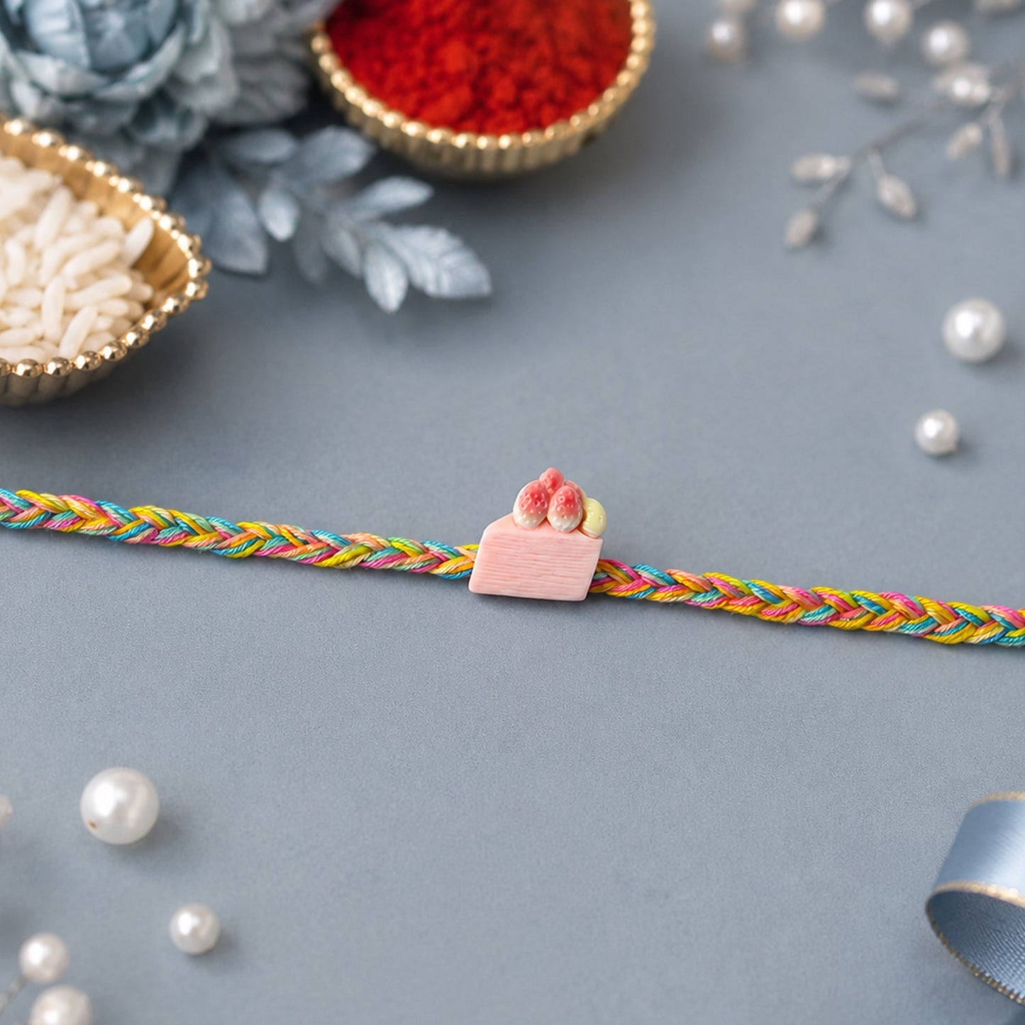 Designer strawberry cake charm rakhi with intricate detailing
