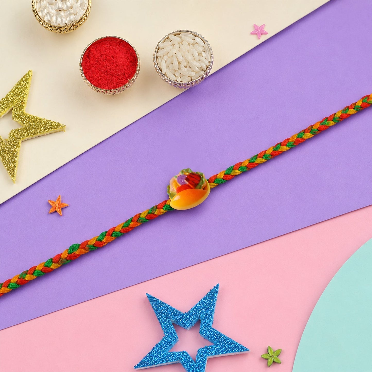 Top-down perspective of the fancy Dori Rakhi with fruit motifs.