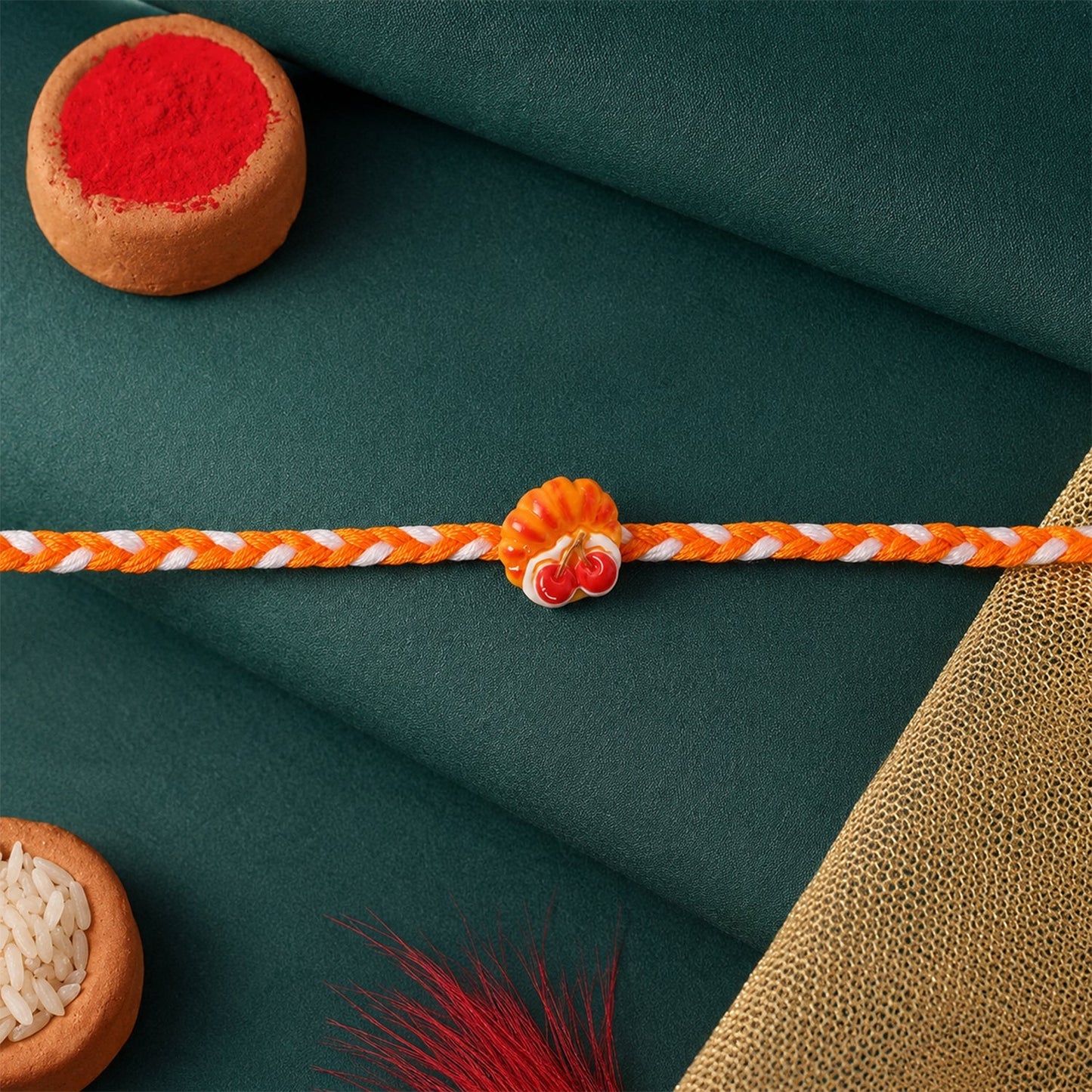 Overhead view of the Cherry Pastry Charm Rakhi, ready for Raksha Bandhan.