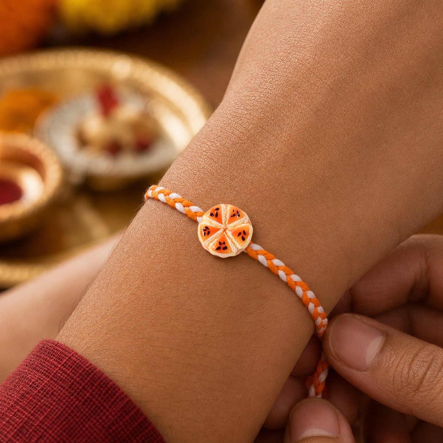 Close-up of Orange Slice Charm Rakhi highlighting details