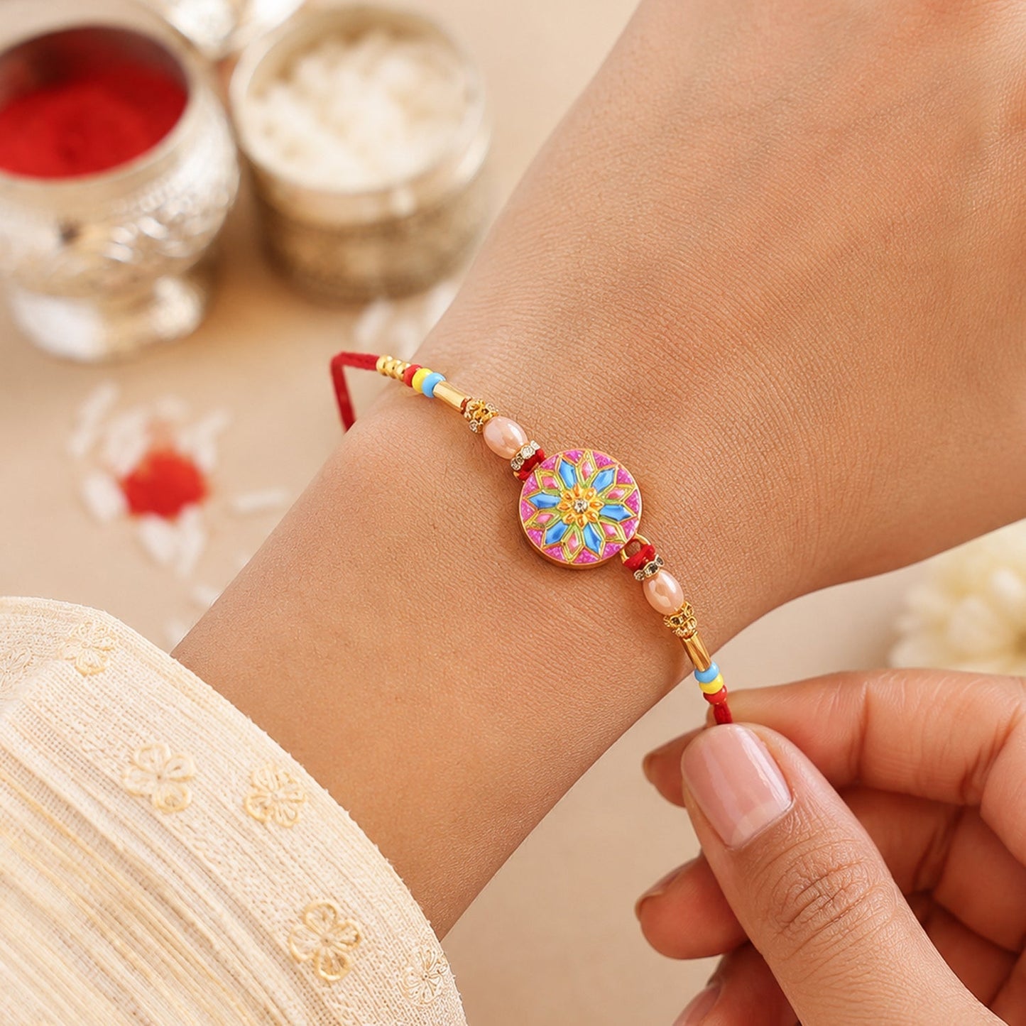 Designer rakhi showcasing detailed meenakari charm and beads