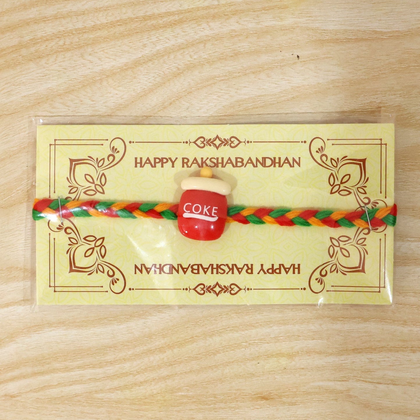 Decorative Coke bottle charm rakhi tied on wrist for brother