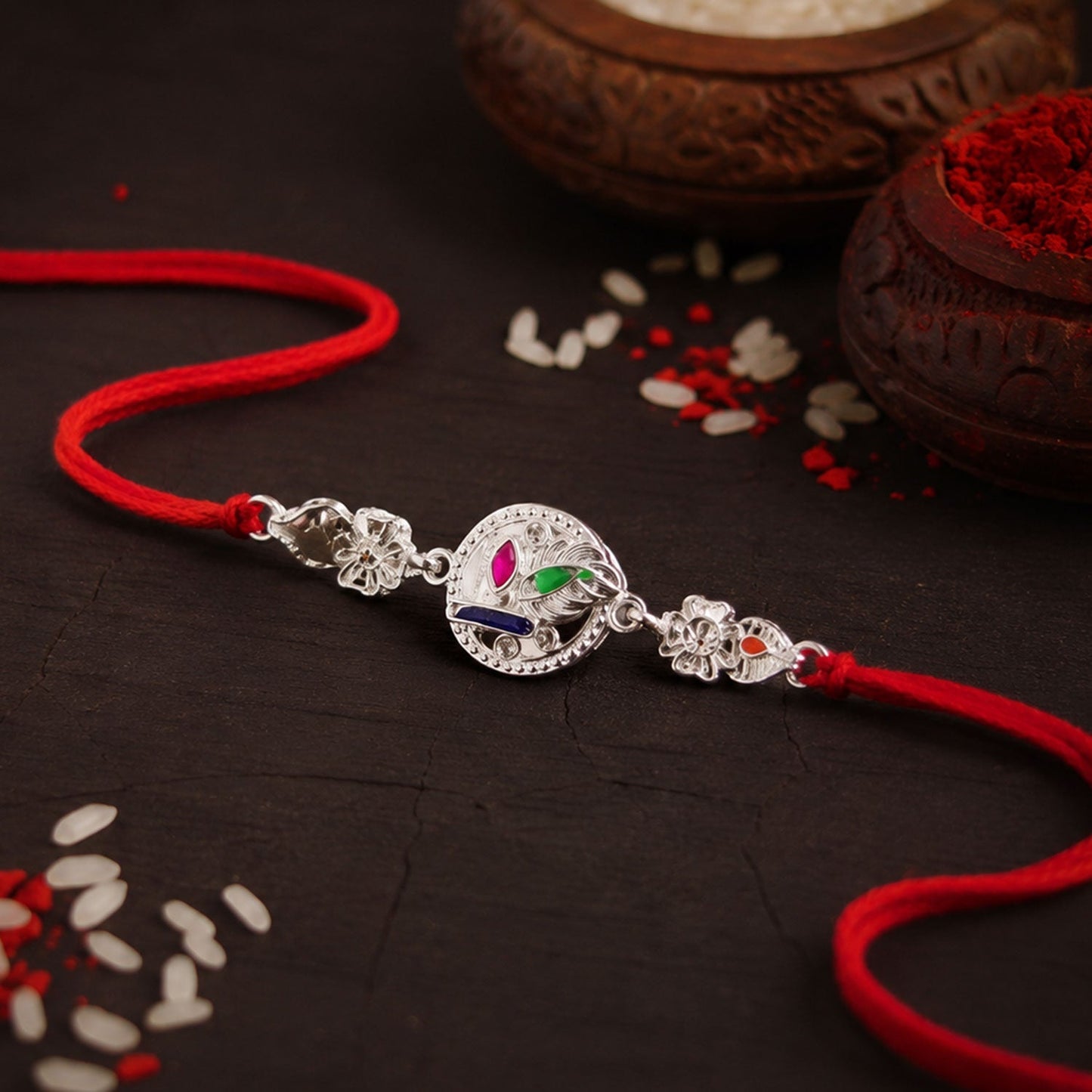 Silver rakhi tied with decorative thread for Raksha Bandhan