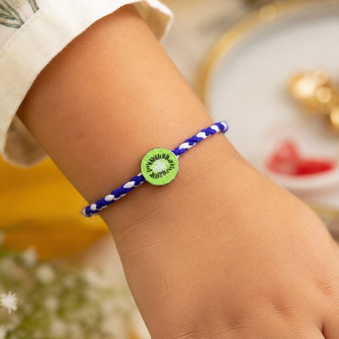 Close-up of kiwi fruit charm on rakhi thread for brother