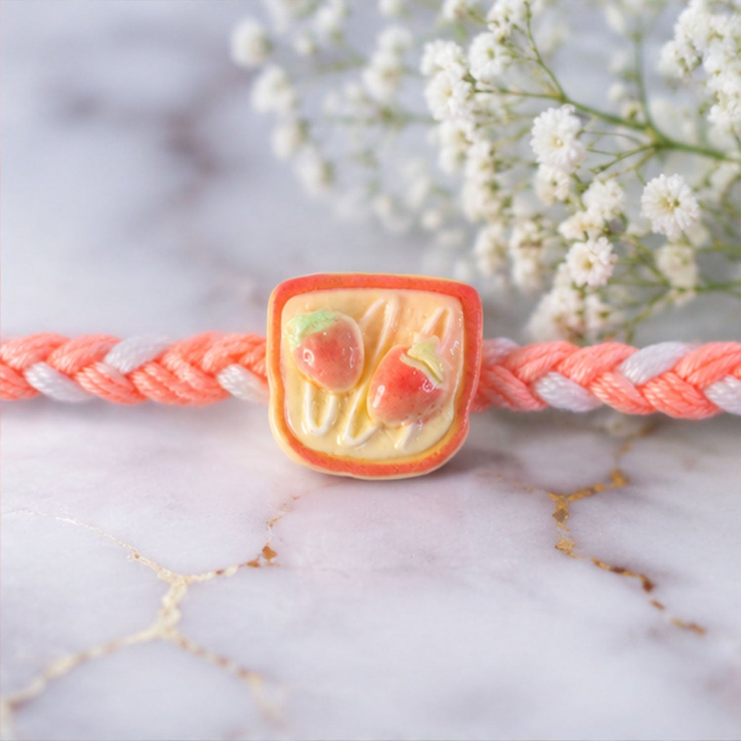 Strawberry Toast Rakhi displayed on a festive background.