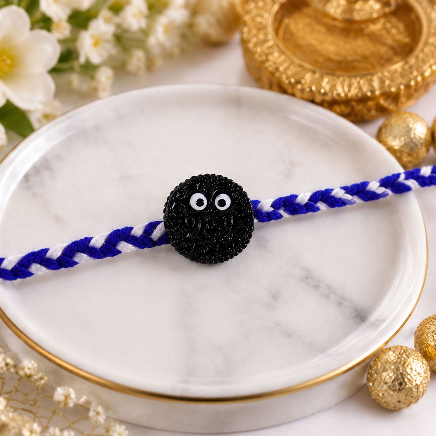 Close-up of cookie eyes charm on festive Rakhi for brothers