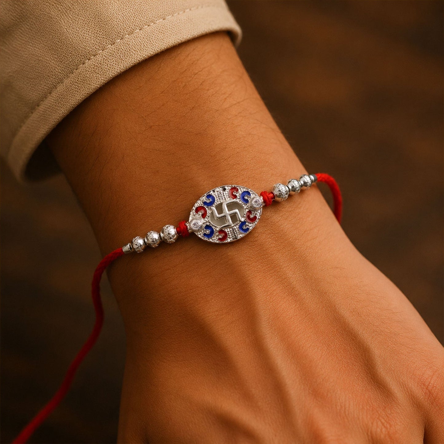 Side angle of Silver Swastik Oval Meena Charm Rakhi with durable dori