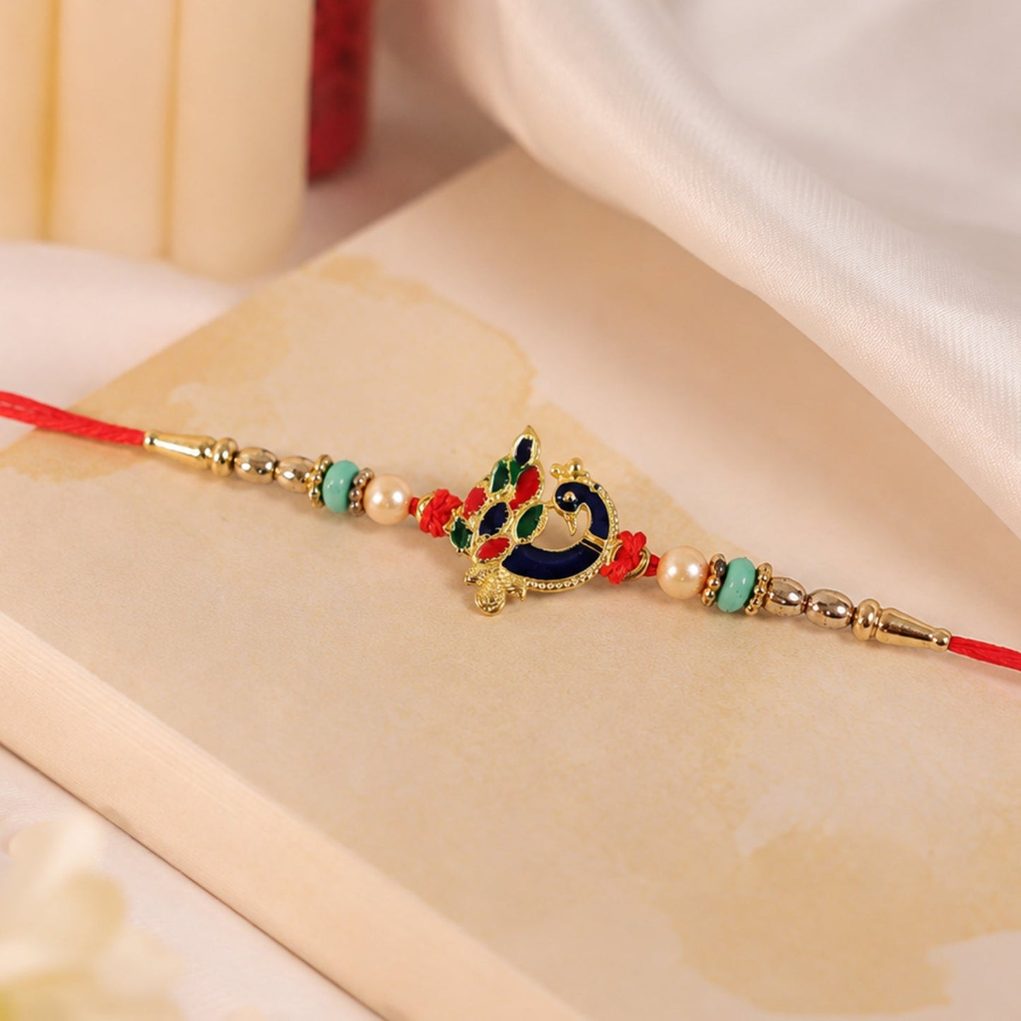 Side view of meenakari peacock Rakhi on wrist