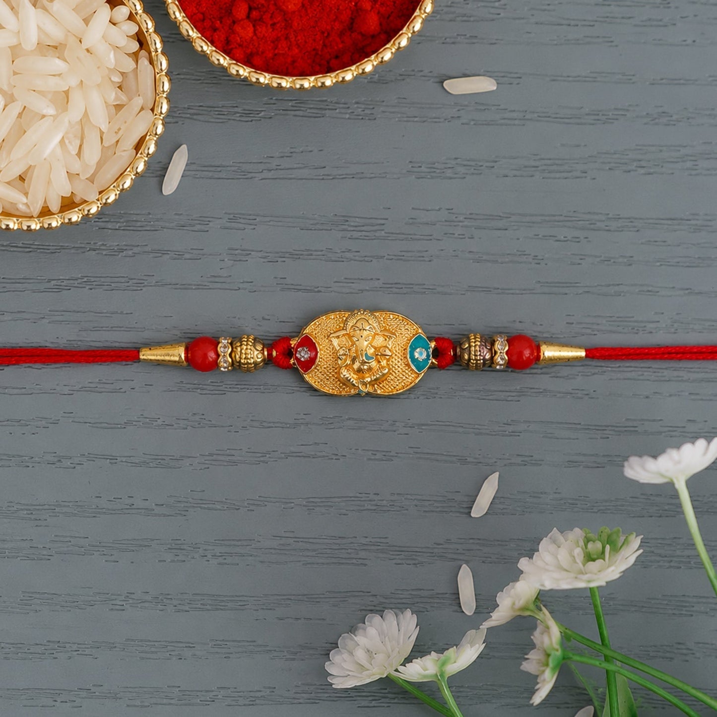 Side view of Ganesh charm on Rakhi with antique beads