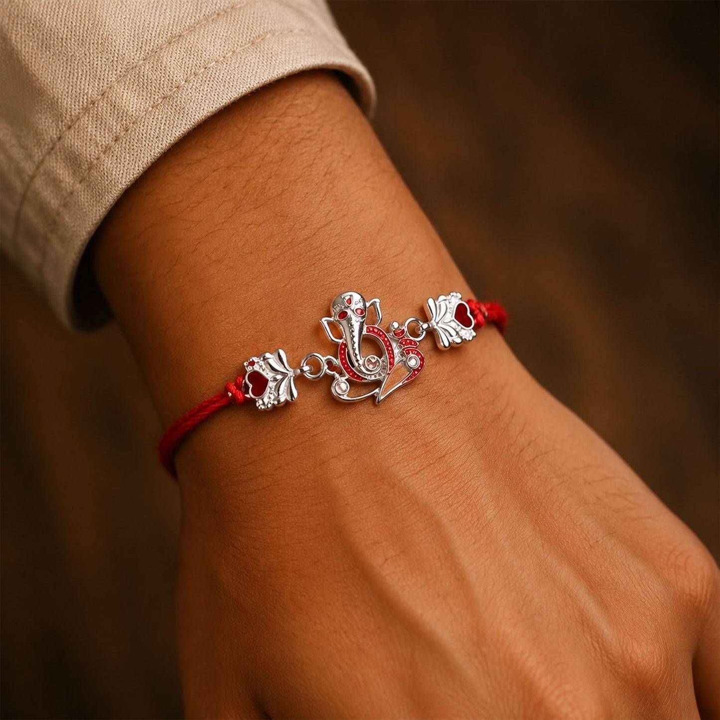 Close-up of Silver Ganpati Heart Charm on rakhi