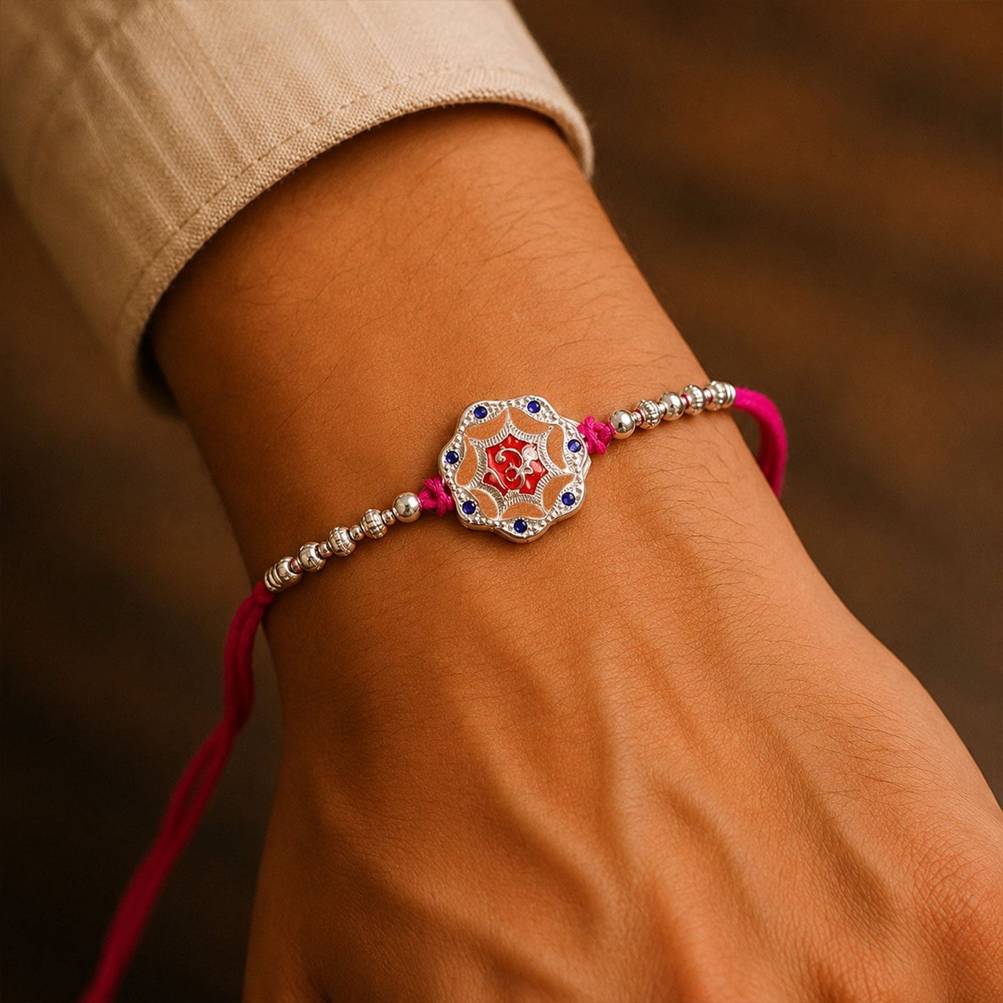 Silver floral charm rakhi on white background, elegant sibling gift