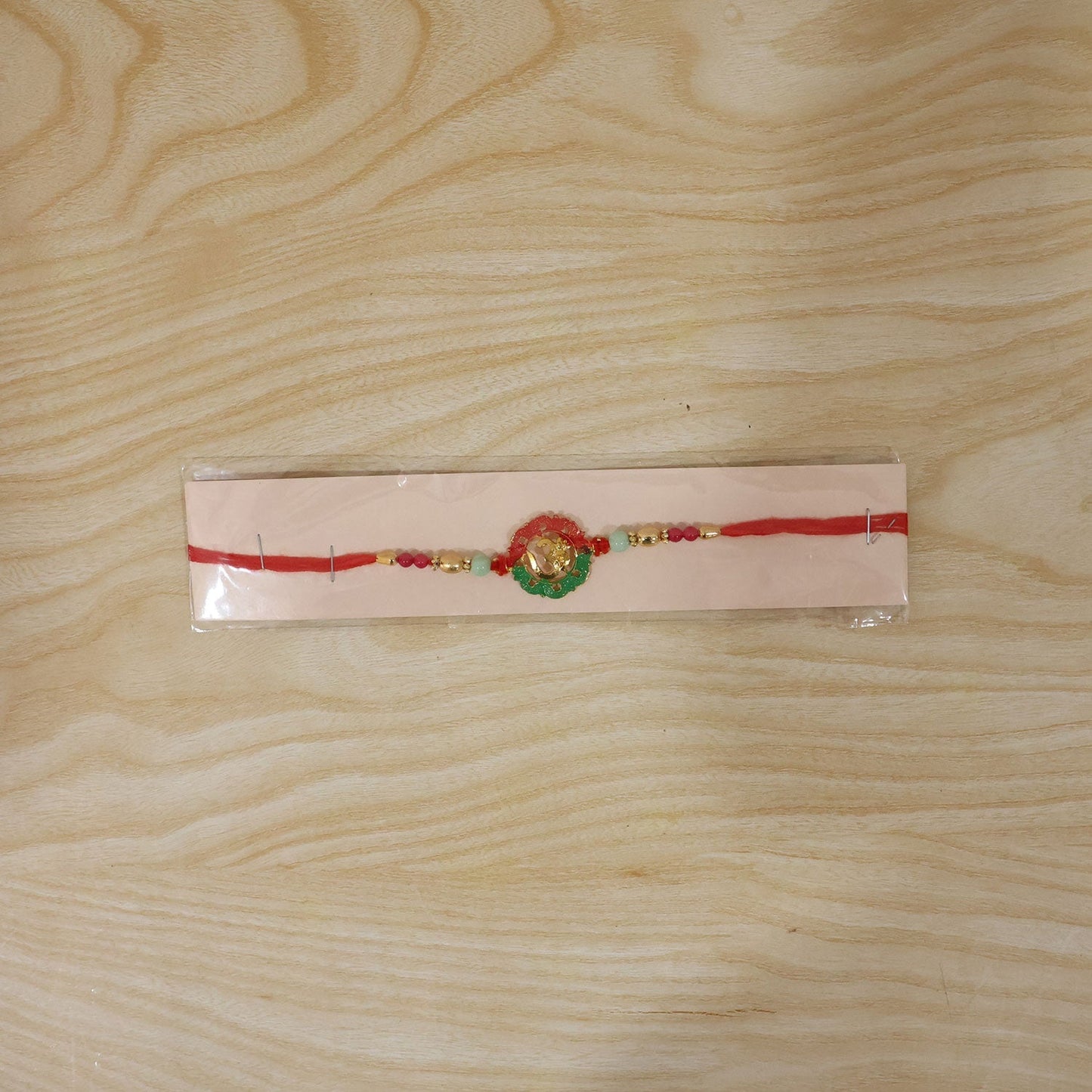 Traditional Golden Om rakhi with decorative beads for Raksha Bandhan