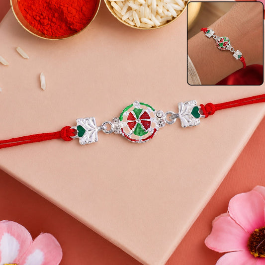 Silver pinwheel heart rakhi with red and gold thread