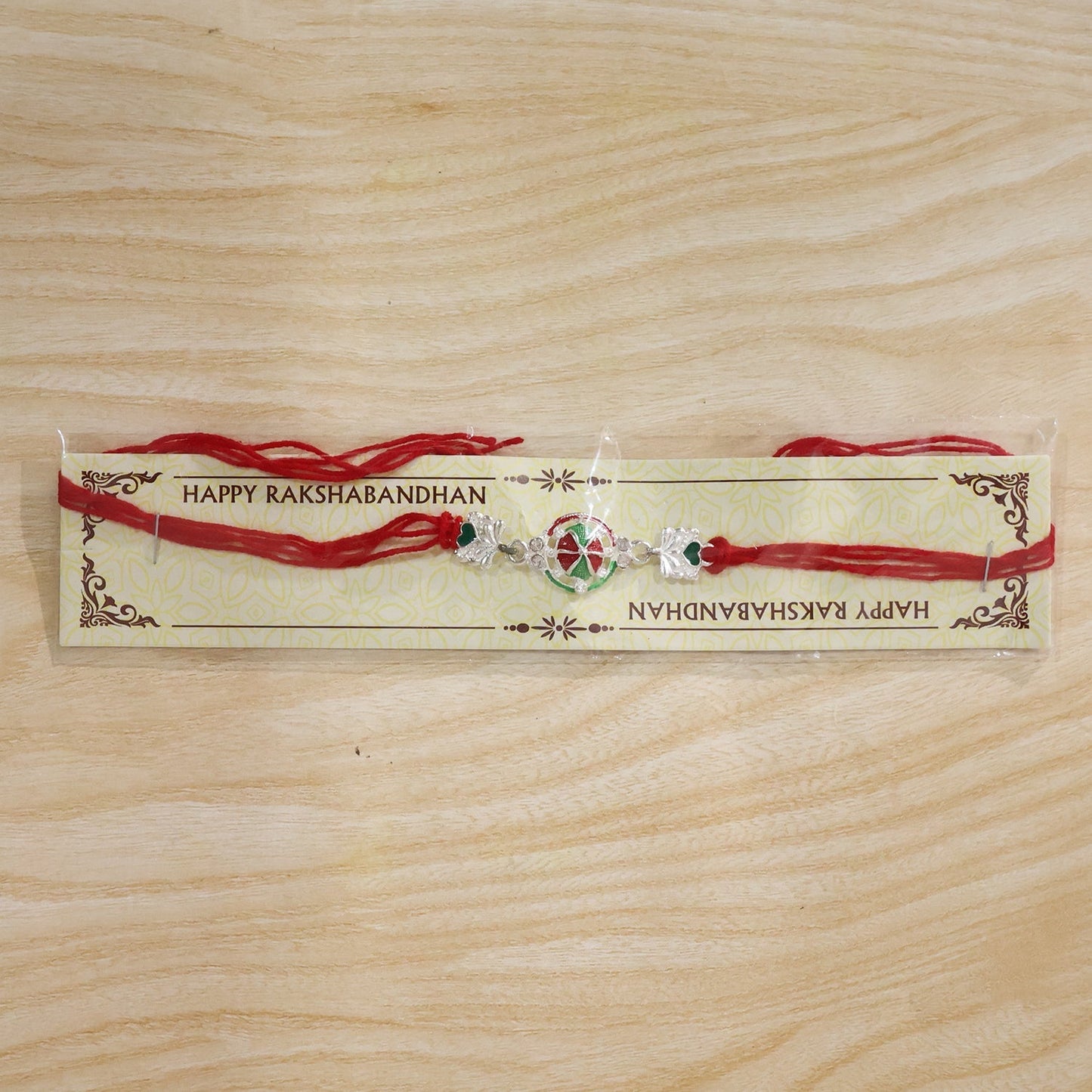 Silver pinwheel heart rakhi with fine thread decorations