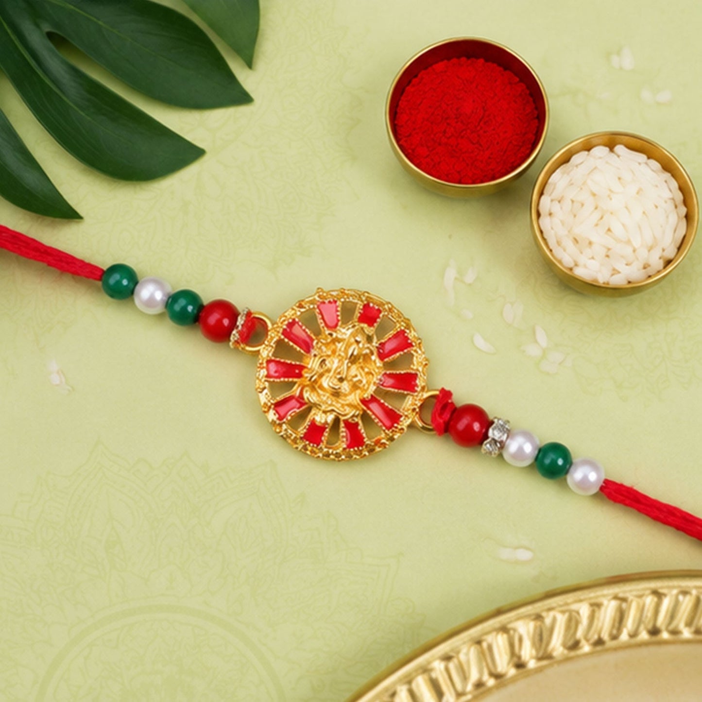Elegant Golden Ganesha wheel Rakhi with decorative accents for Raksha Bandhan
